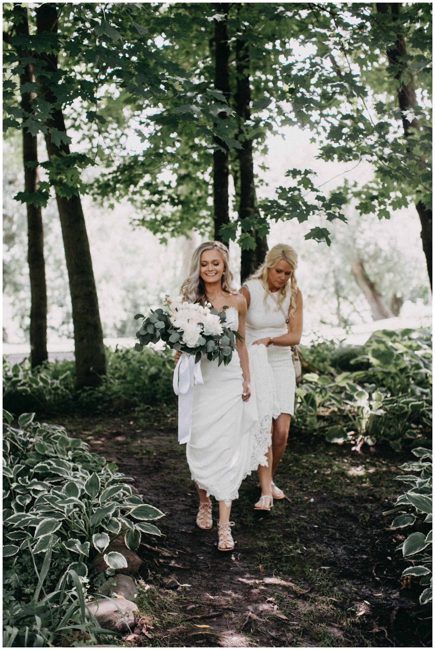 Bride walking in woods for first look with groom at Minnesota farm wedding venue