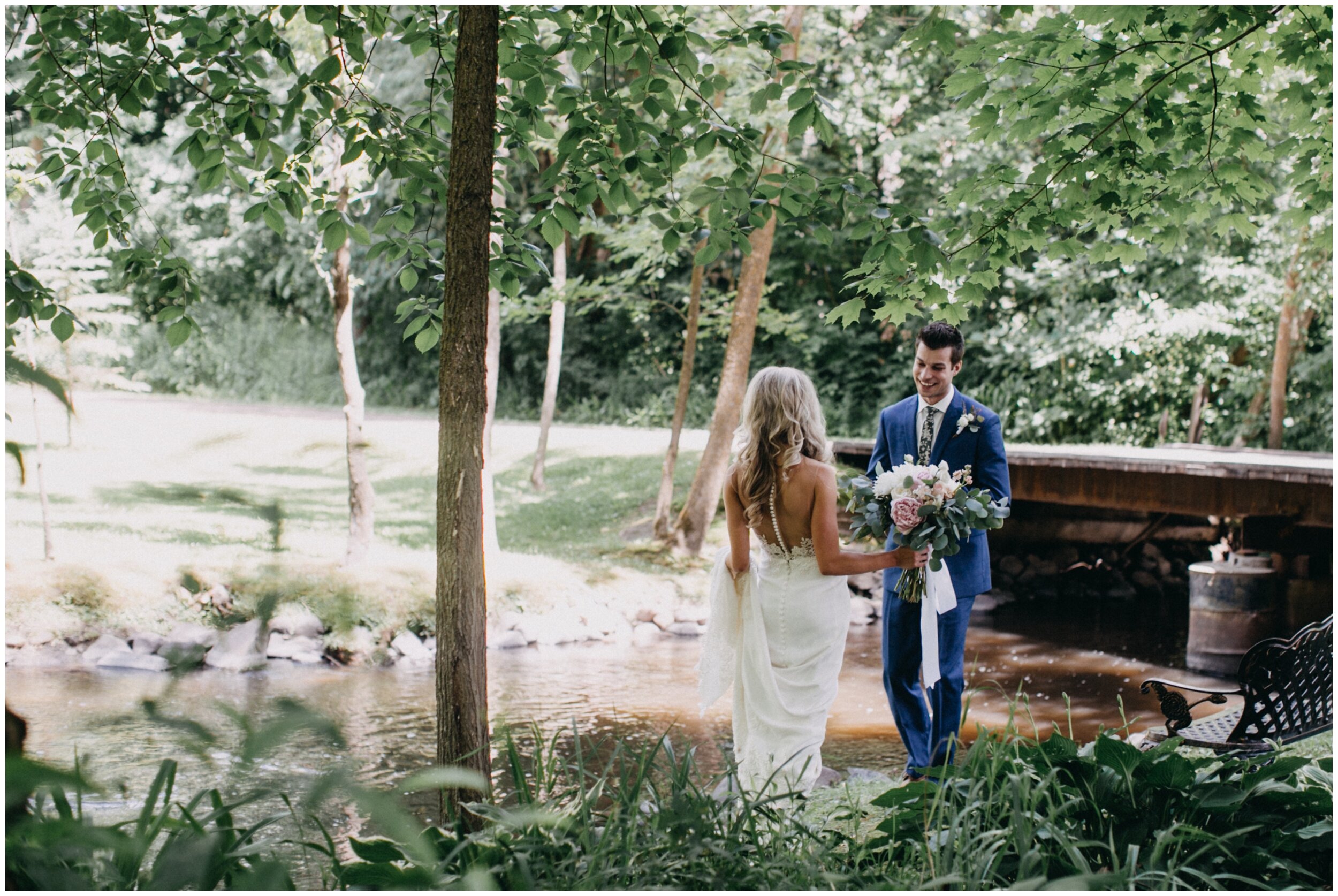 Bride and groom first look in the woods at Minnesota barn wedding venue