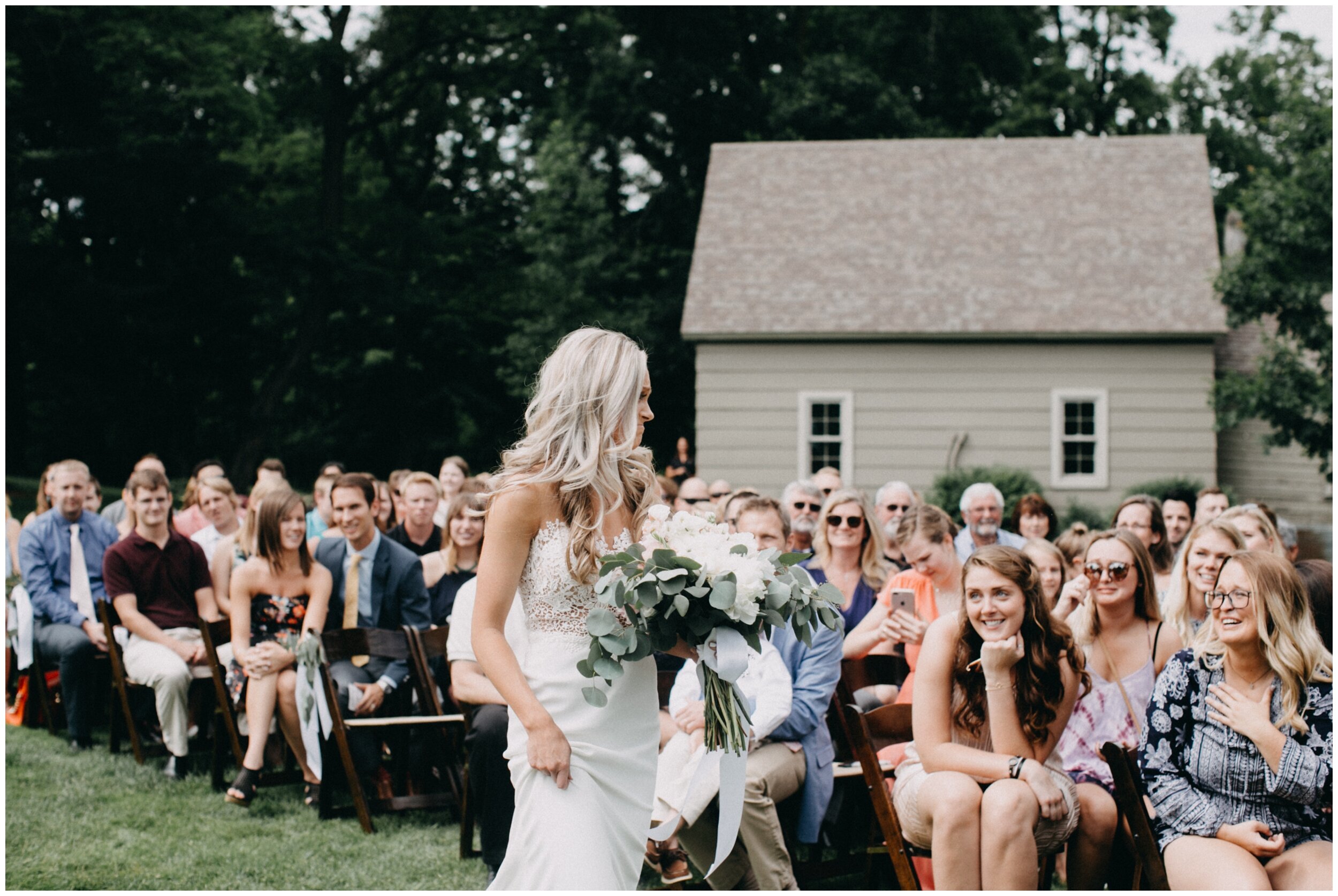 Bride walking down aisle during outdoor wedding ceremony at Creekside Farm in Rush City, Minnesota