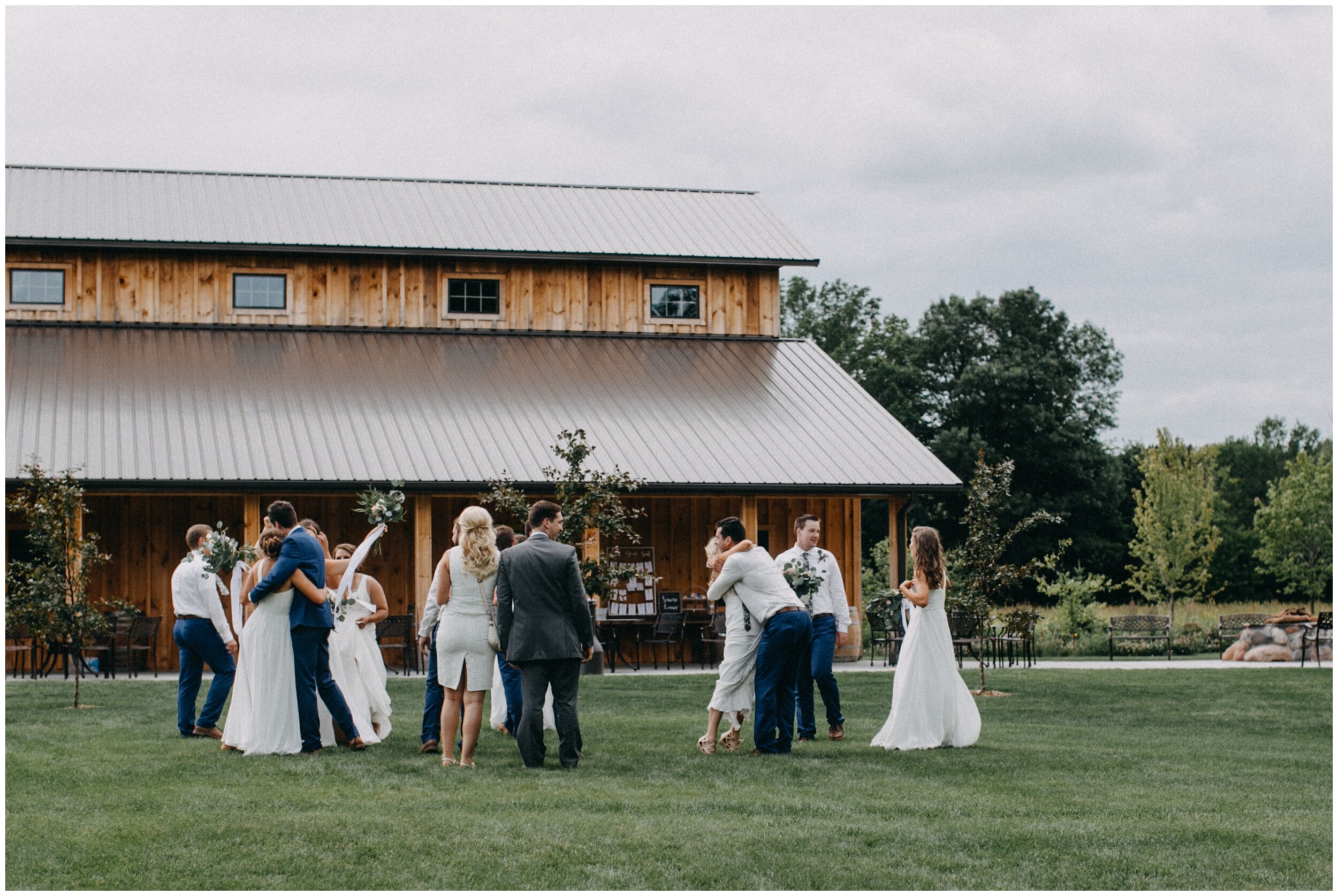 Wedding party celebrating in front of barn after outdoor summer wedding ceremony at Creekside Farm