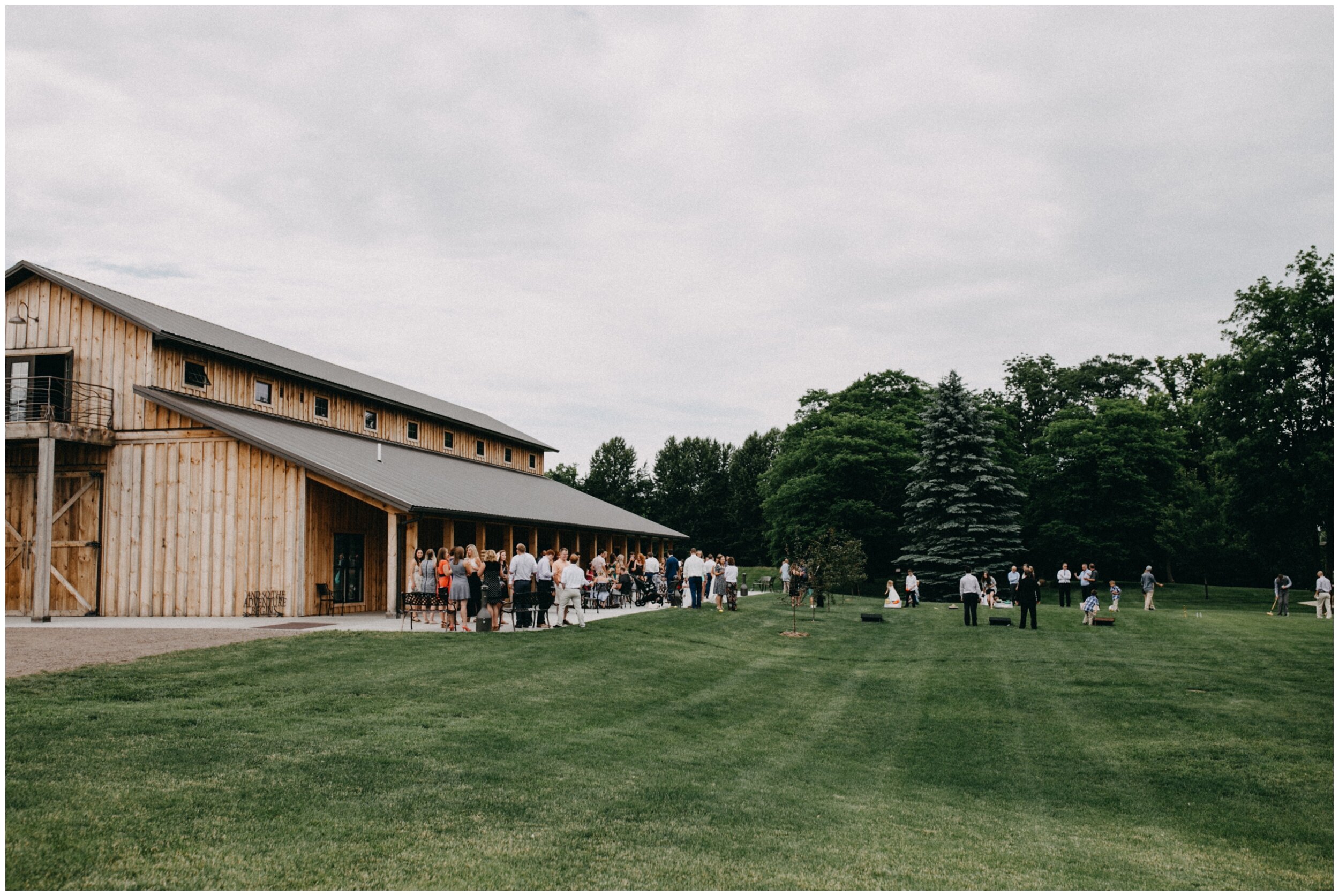 Guests standing outside modern Minnesota barn wedding venue