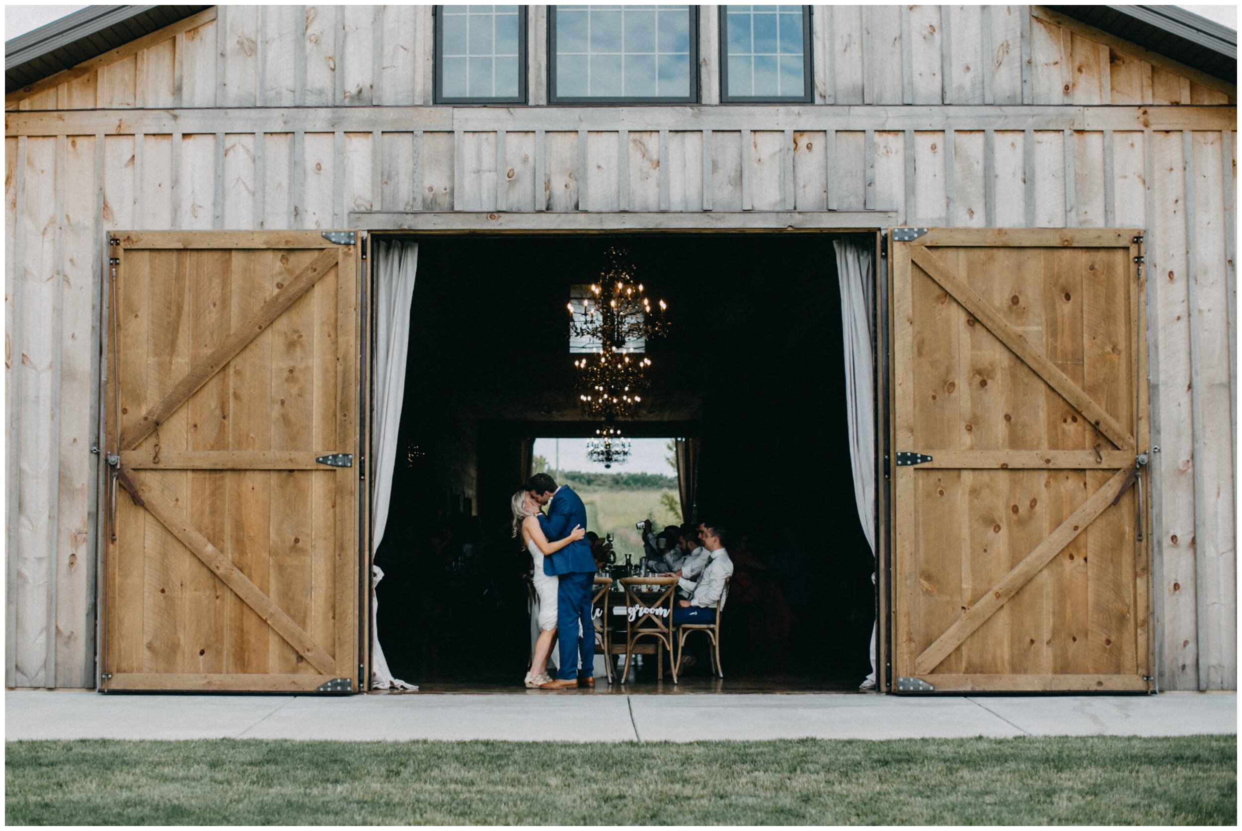Bride and groom kissing in barn during wedding reception at Creekside Farm in Rush City, Minnesota