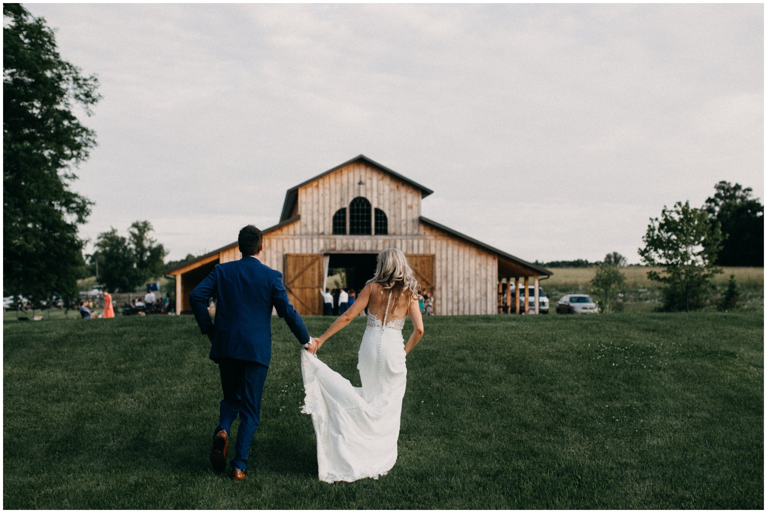 Bride and groom running towards barn at Creekside Farm in Rush City, Minnesota