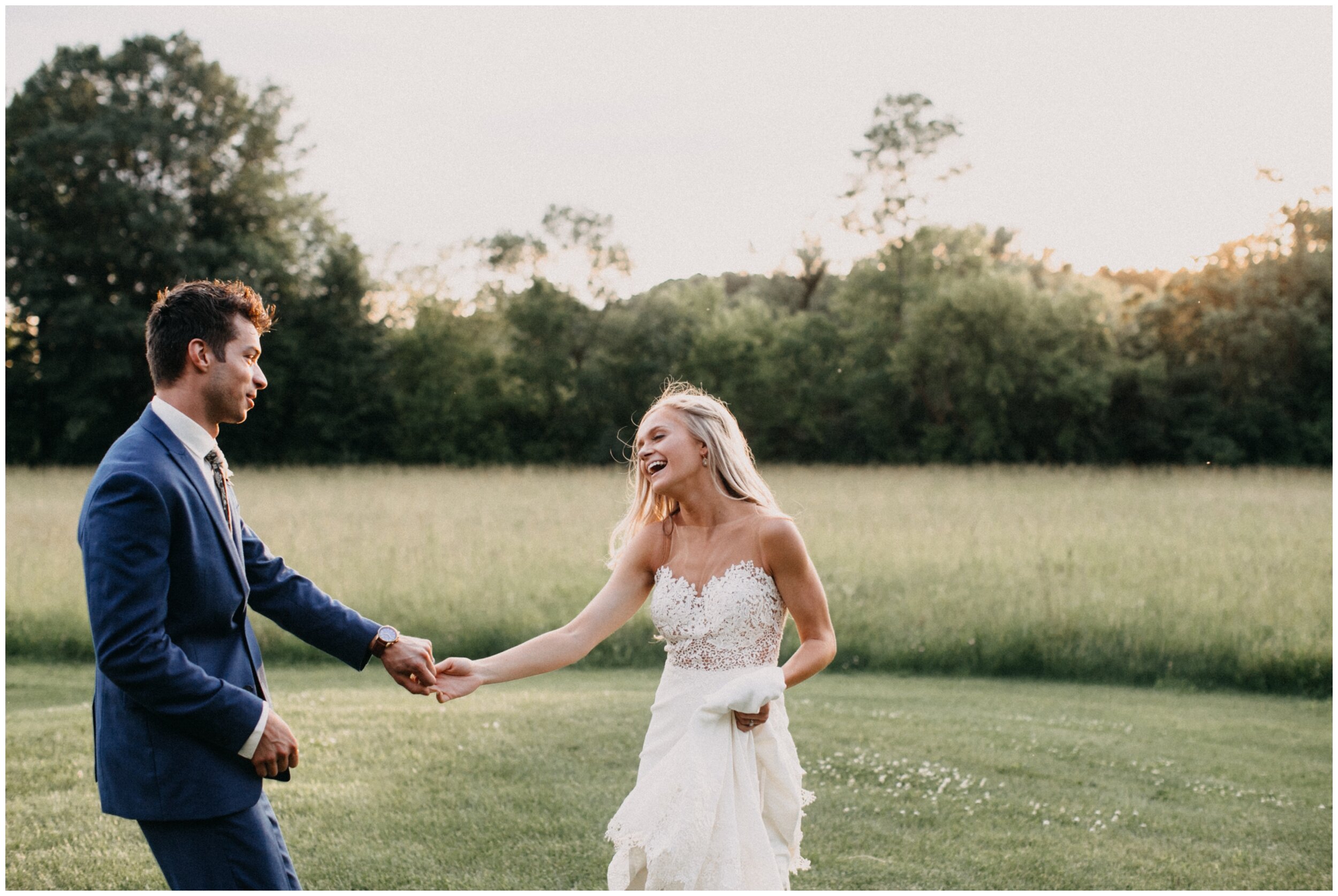Bride and groom dancing in field during sunset at Minnesota barn wedding 