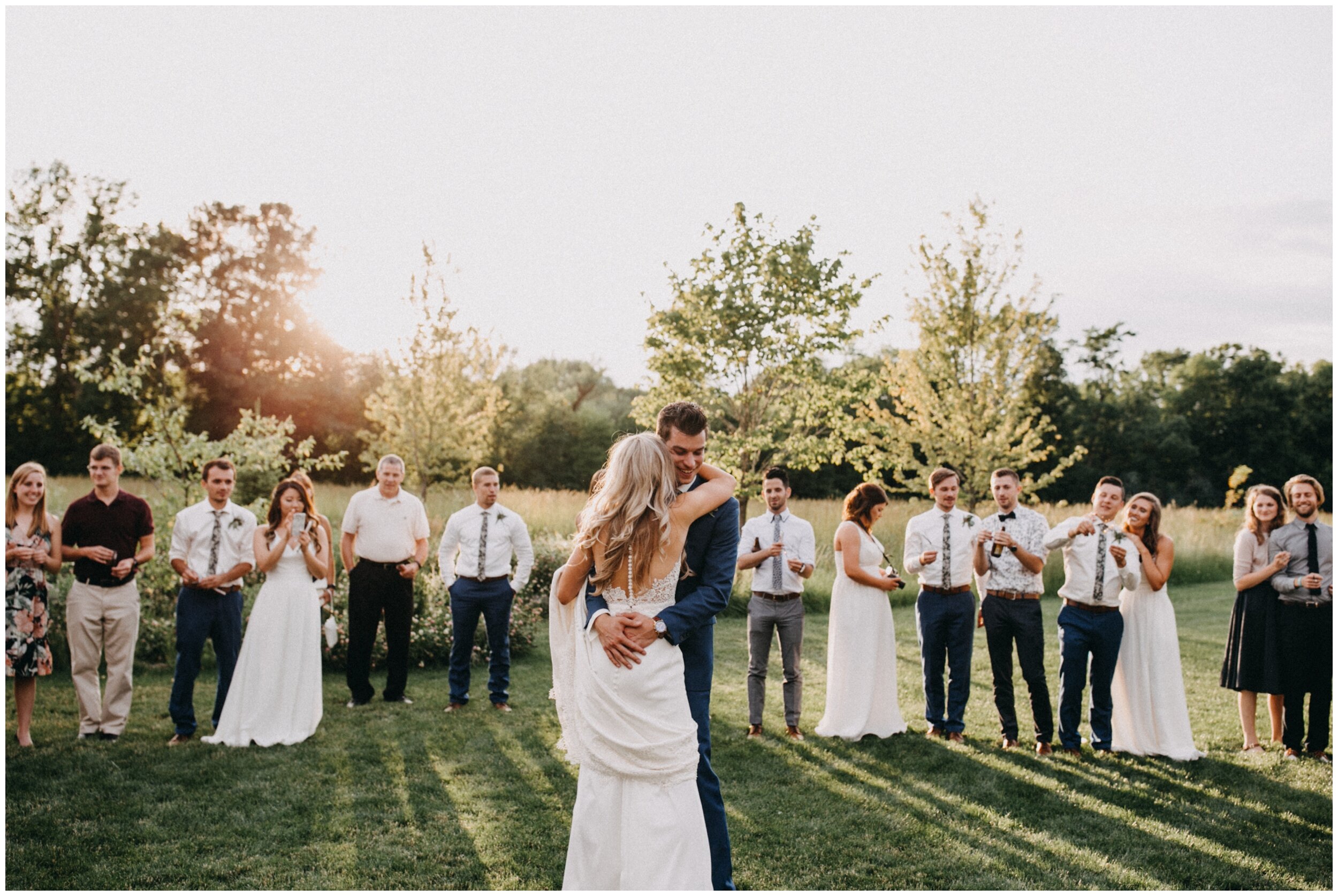Bride and groom sparkler dance during sunset at outdoor Minnesota barn wedding