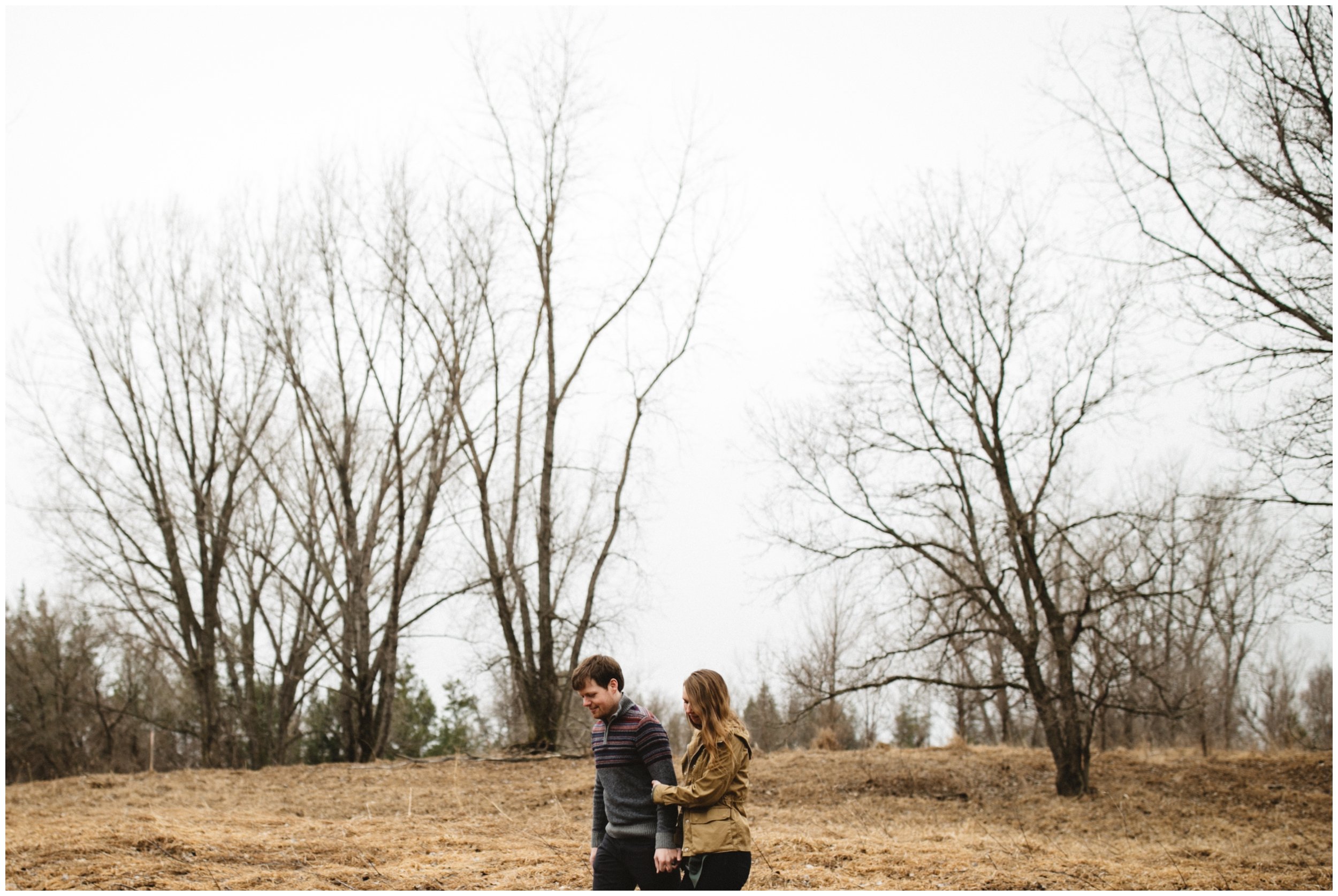 Couple holding hands while walking in the woods during Brainerd Minnesota engagement session