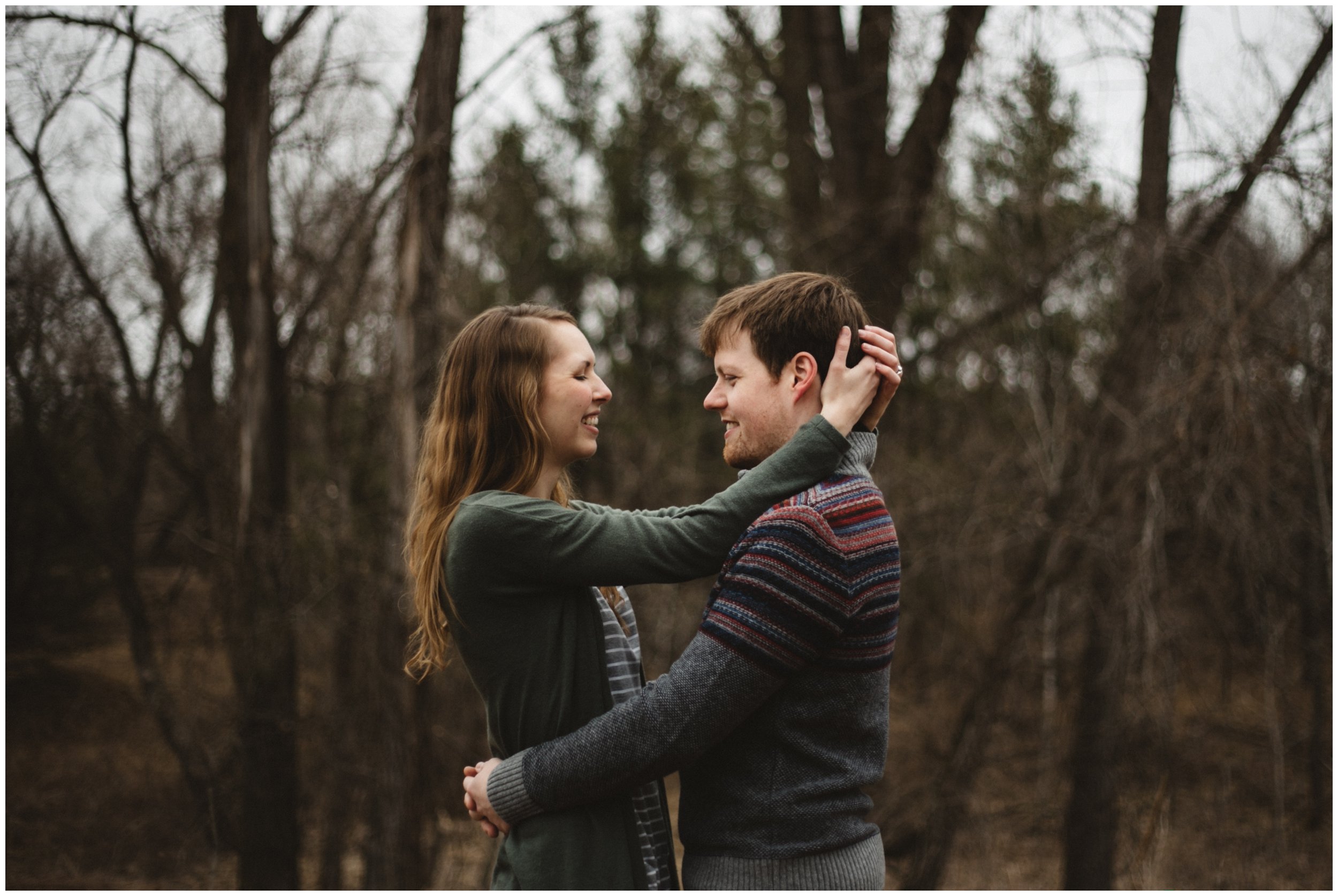 Couple smiling with arms wrapped around each other during Brainerd, Minnesota engagement session in the woods