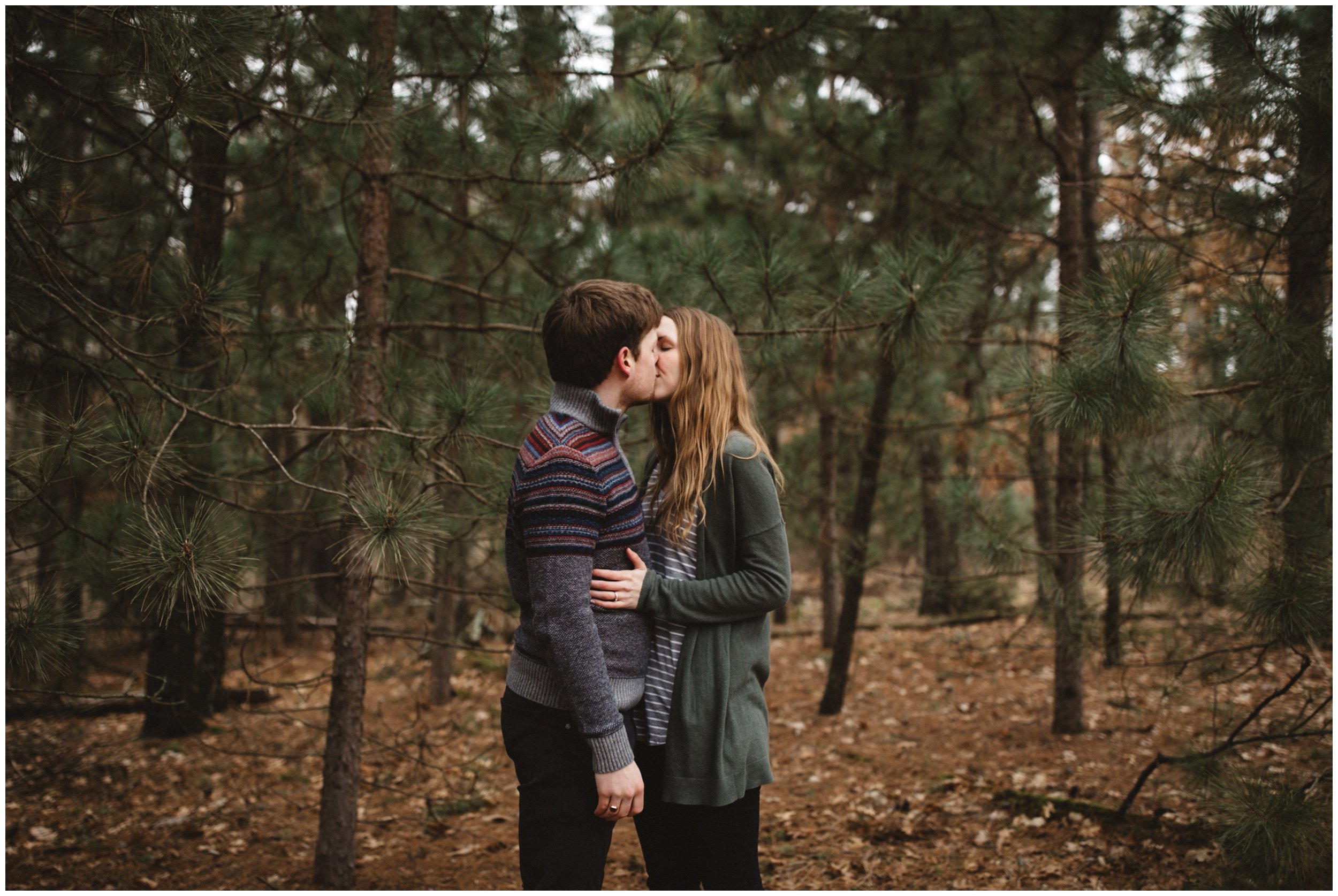 Engaged couple kissing in the woods during engagement session in Brainerd, Minnesota