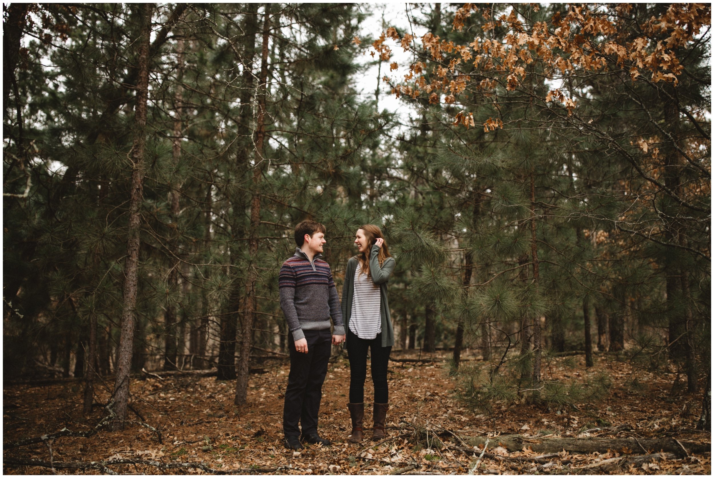 Couple standing in the woods, holding hands in Brainerd Minnesota