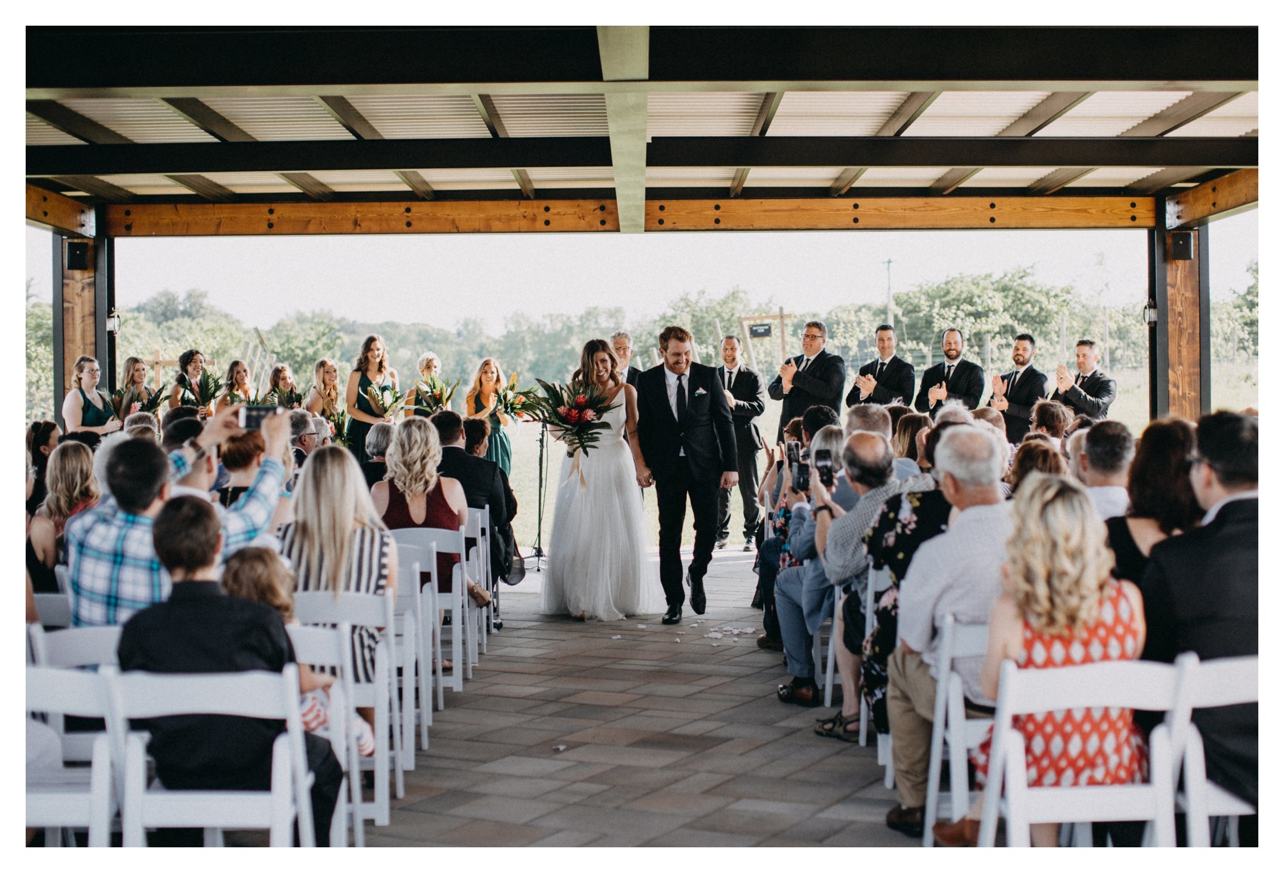 Bride and groom happily walk down aisle after Minnesota vineyard wedding ceremony