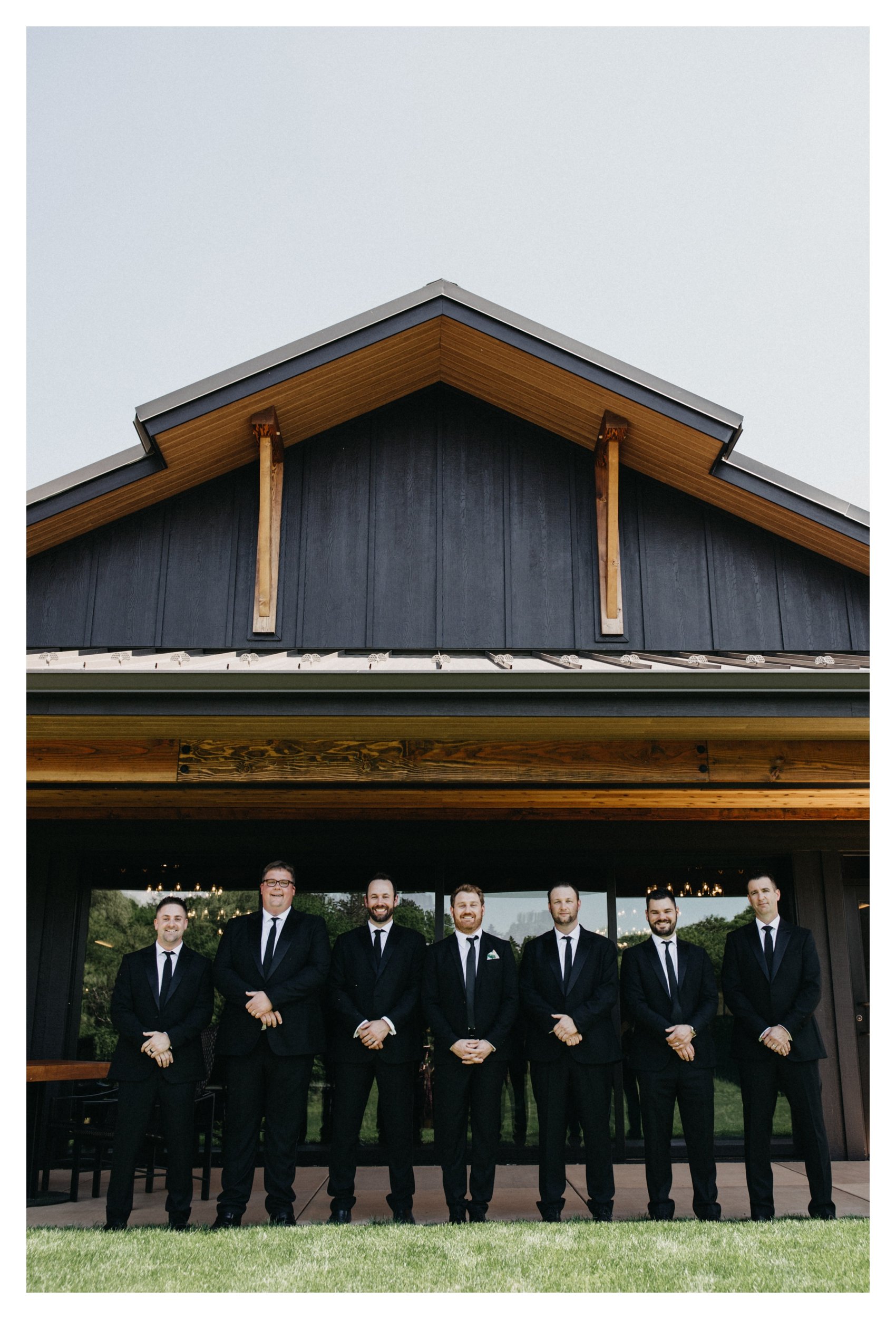 Groom and groomsmen standing in front of 7 Vines vineyard wedding venue
