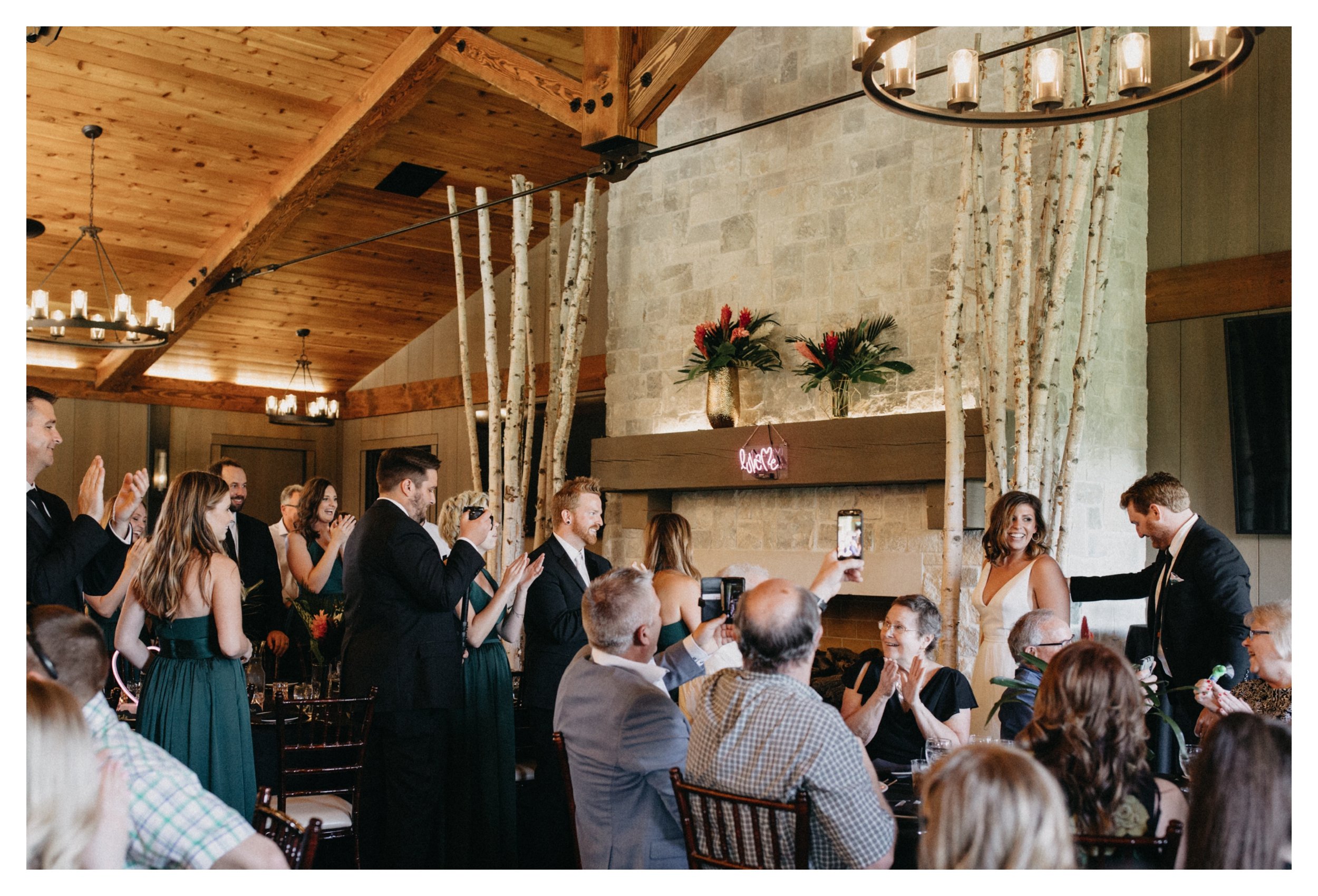 Bride and groom walking into reception as guests cheer at 7 vines vineyard wedding venue