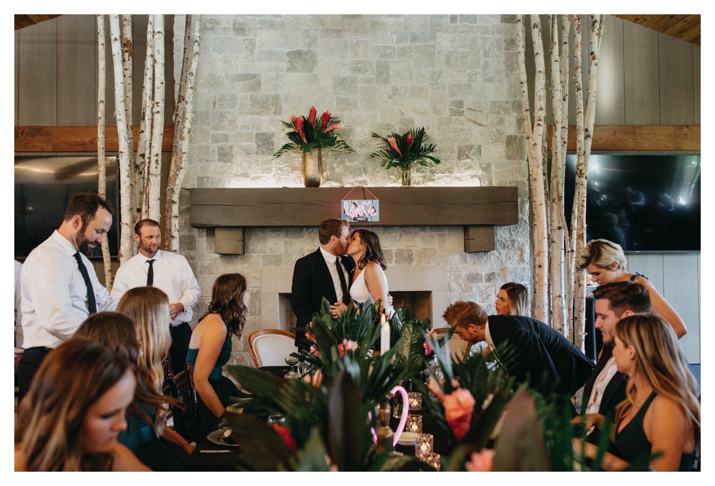 Bride and groom kissing in front of fireplace at 7 vines vineyard wedding reception