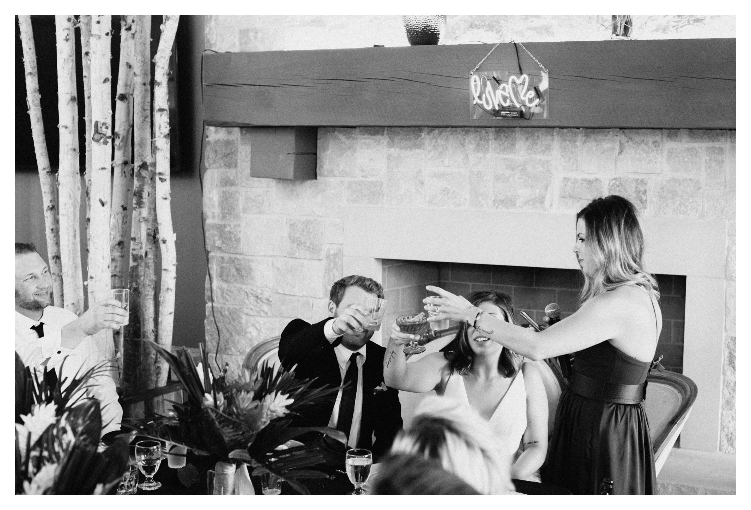 Bridesmaid toasting bride and groom with champagne during 7 vines vineyard wedding reception