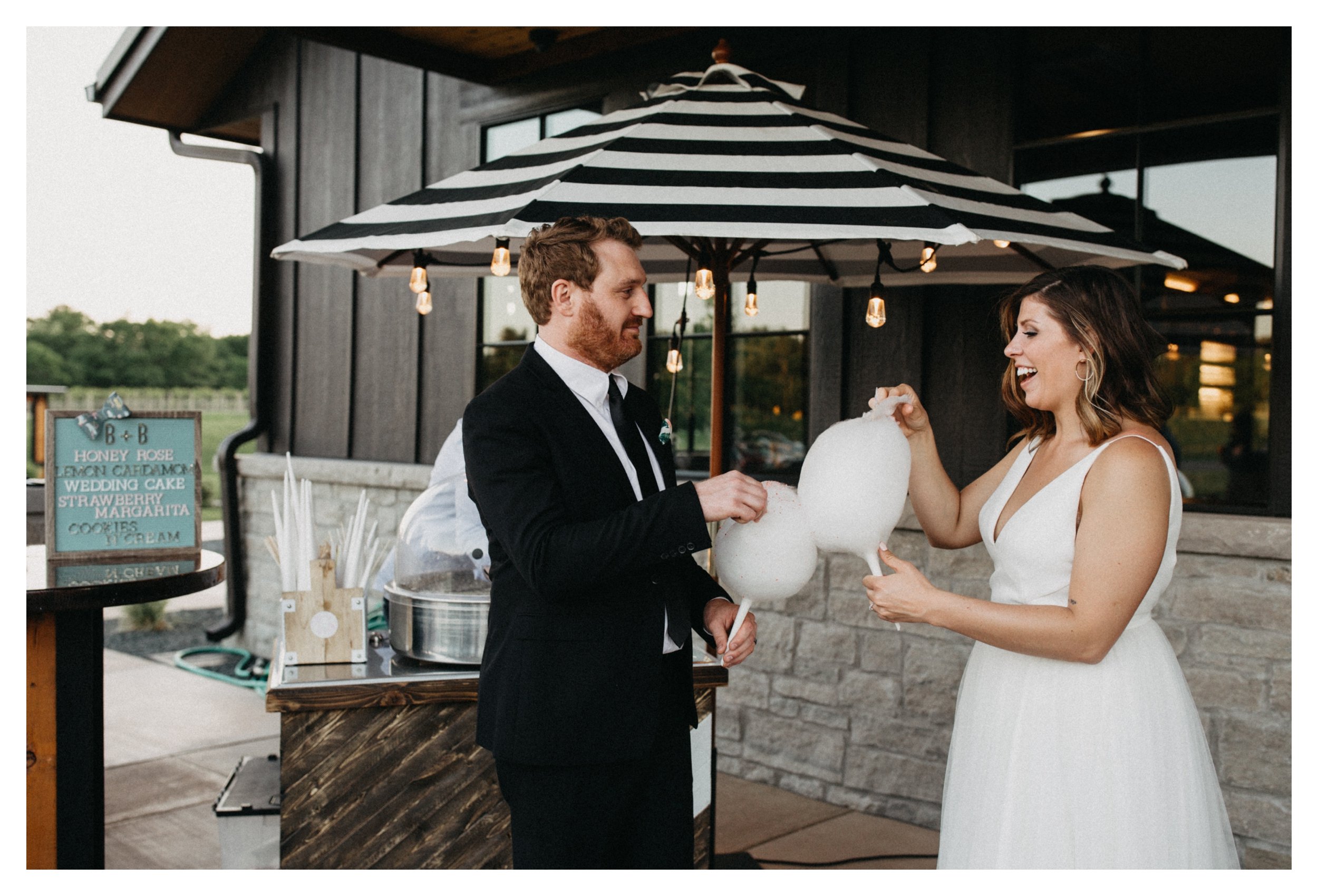 Bride and groom sharing cotton candy dessert at Minnesota vineyard wedding