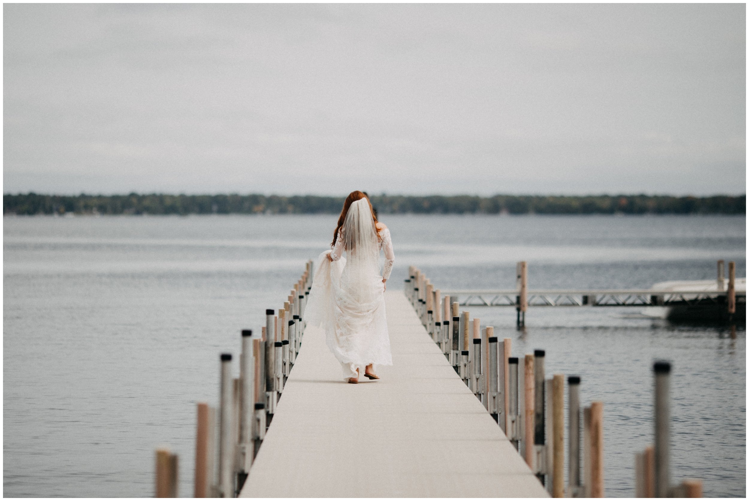 Bride walking on dock towards groom during first look at Gull Lake wedding