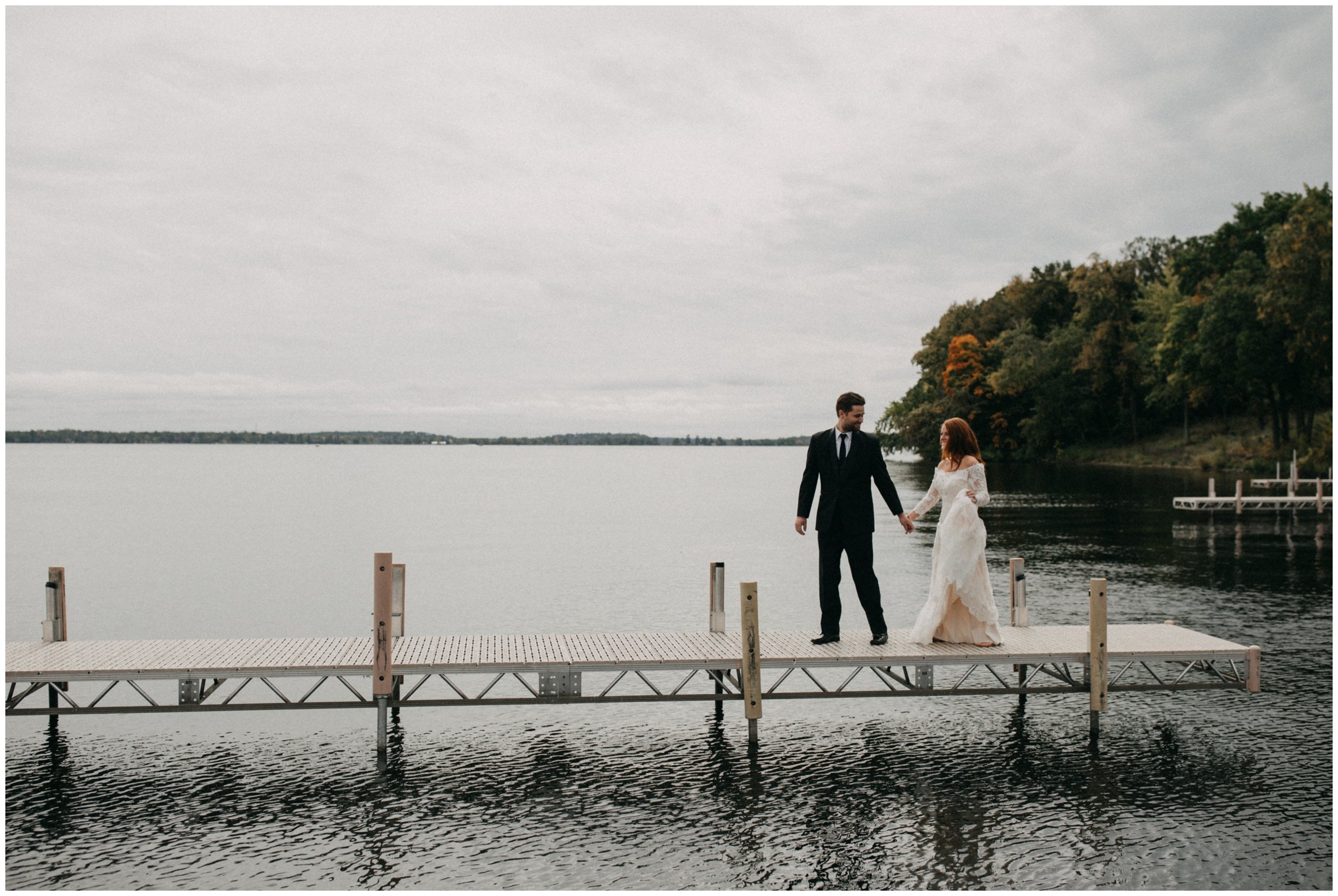 Bride and groom walking on dock on Gull Lake