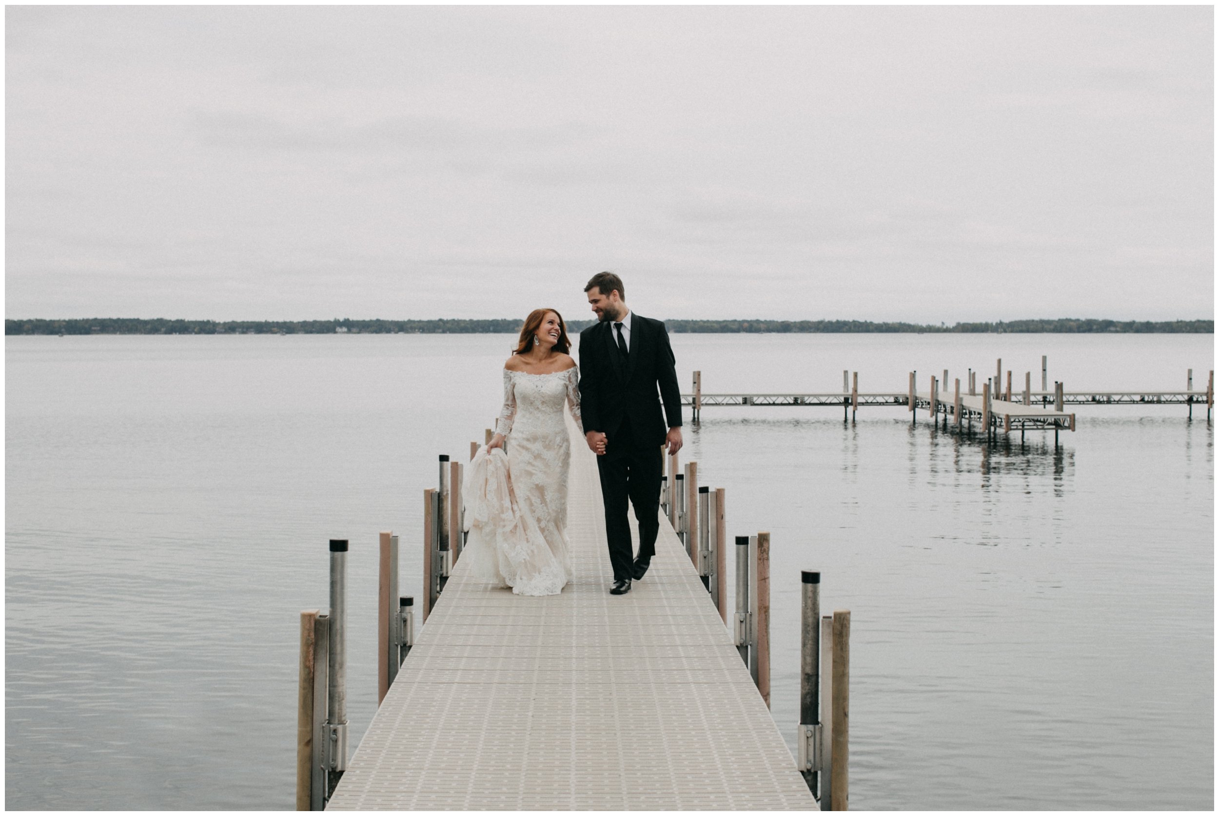 Bride and groom standing on dock on Gull Lake in Nisswa, Minnesota