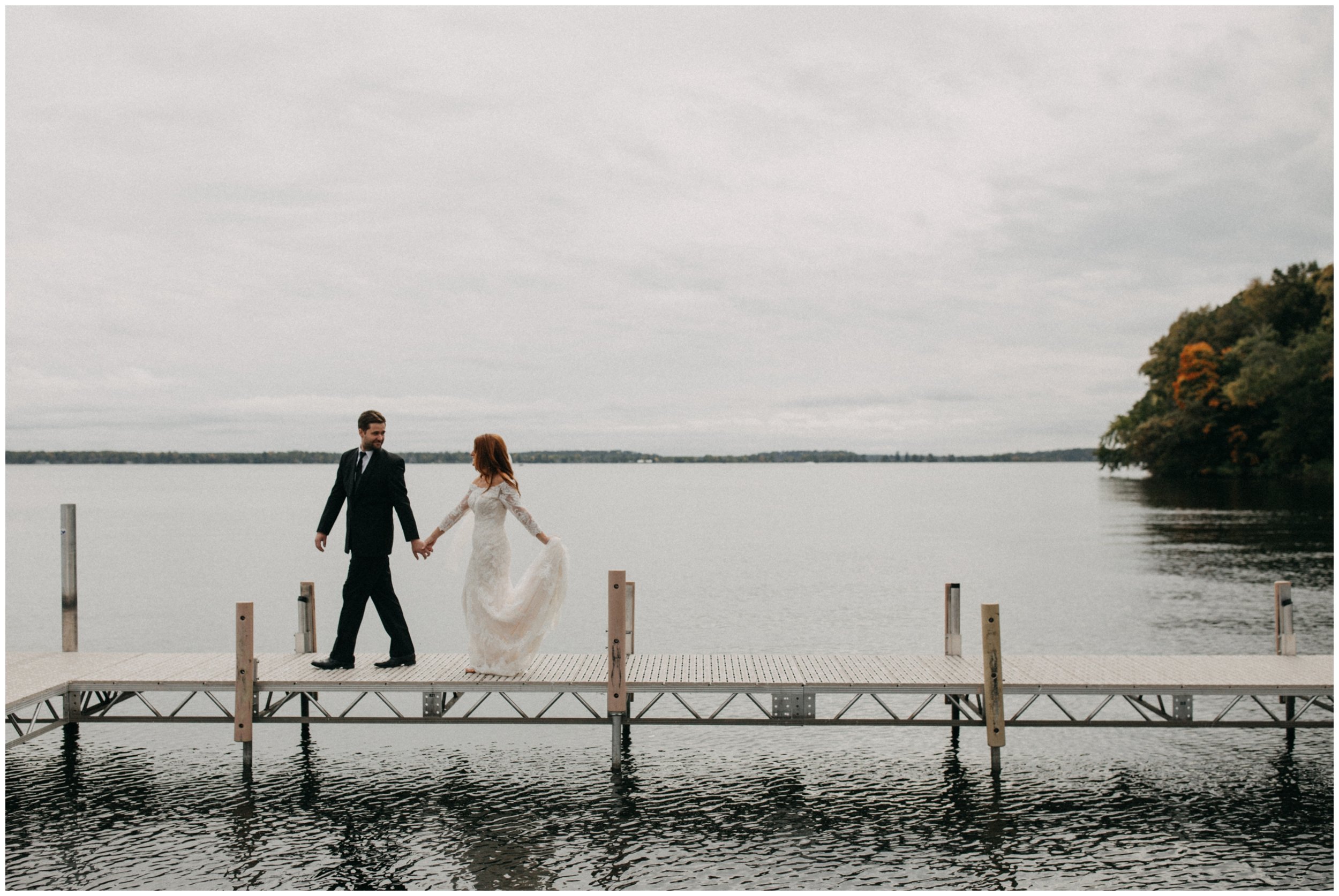 Bride and groom holding hands, walking on dock on Gull Lake in Nisswa, Minnesota
