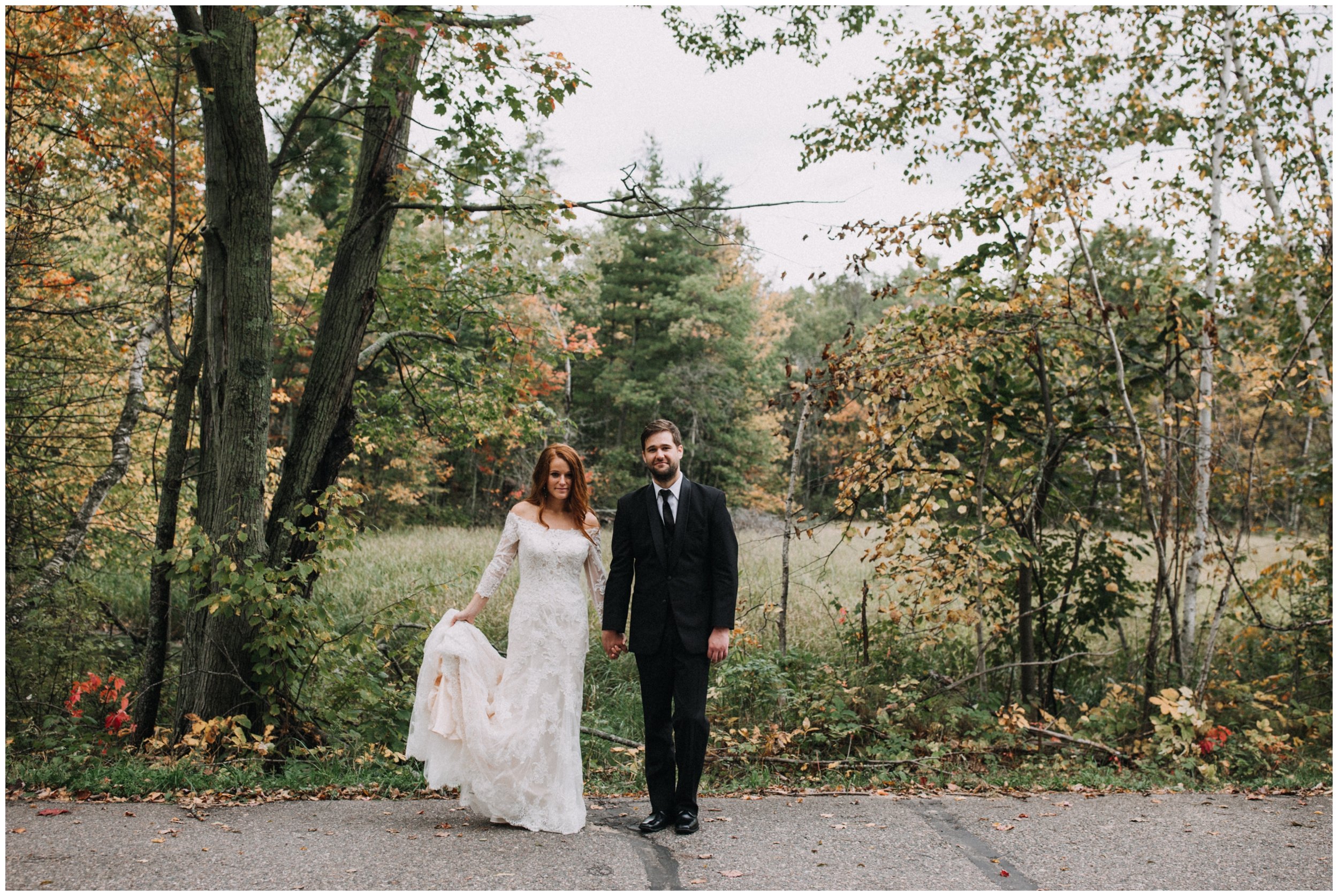 Bride and groom standing on wood road in Nisswa, Minnesota