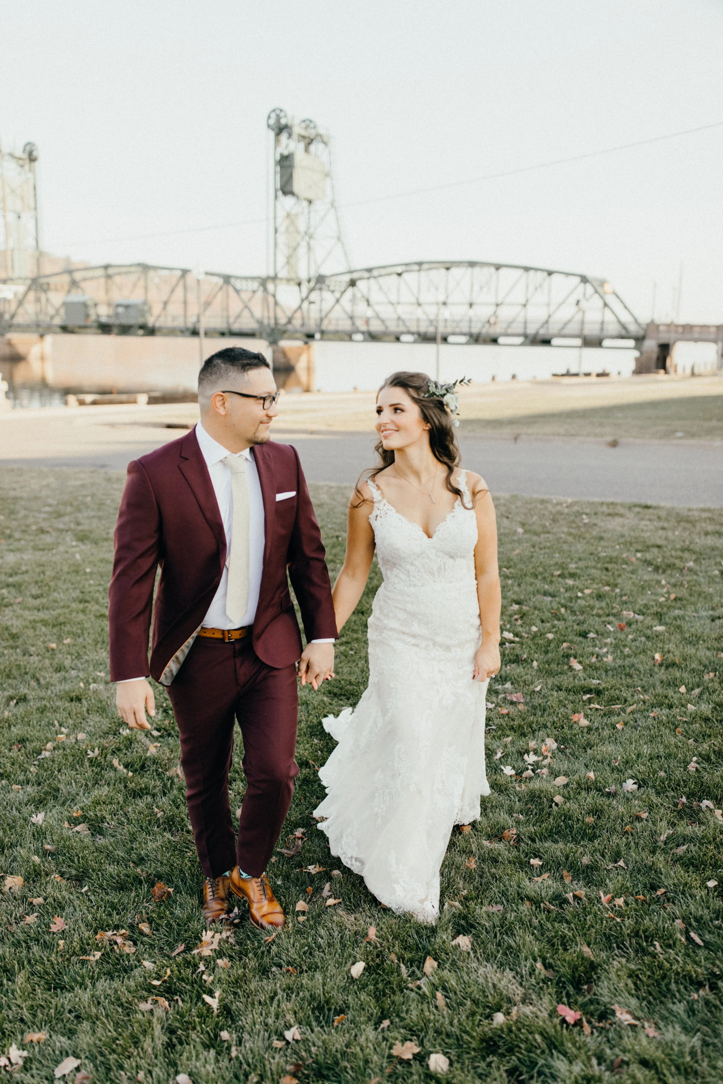 Bride and groom walking near Lift Bride on wedding day in Stillwater, Minnesota
