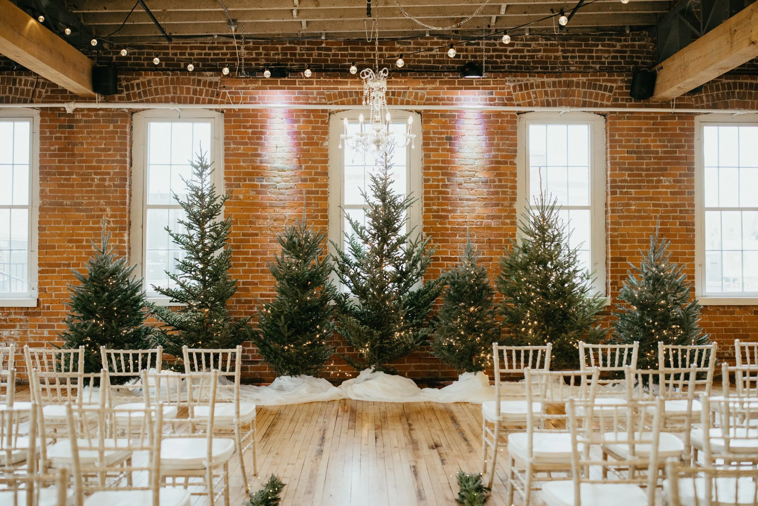 Pine tree wedding ceremony backdrop at JX venue in Stillwater, Minnesota