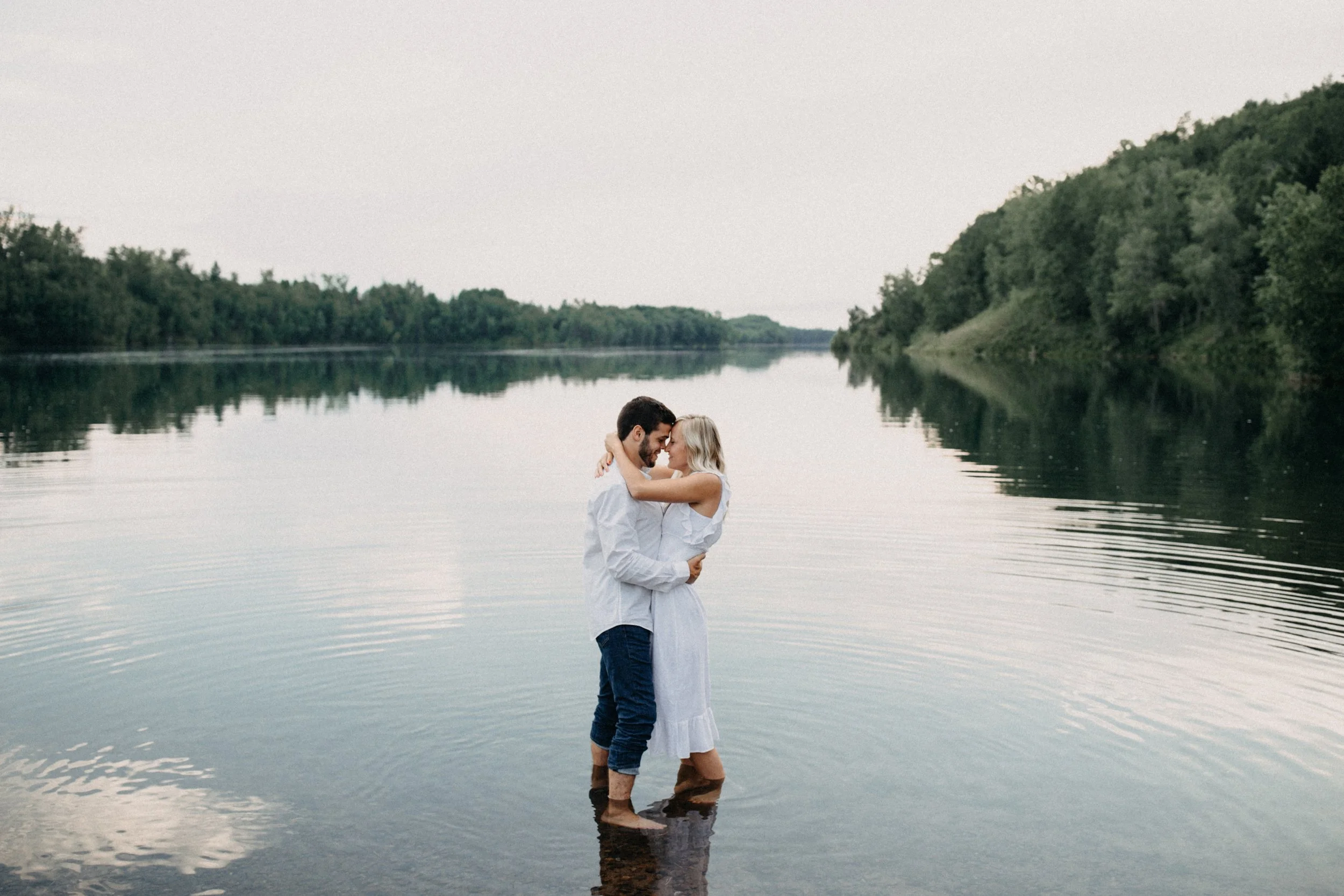 Couple standing in lake during their engagement session at Miner's Lake in Crosby Minnesota