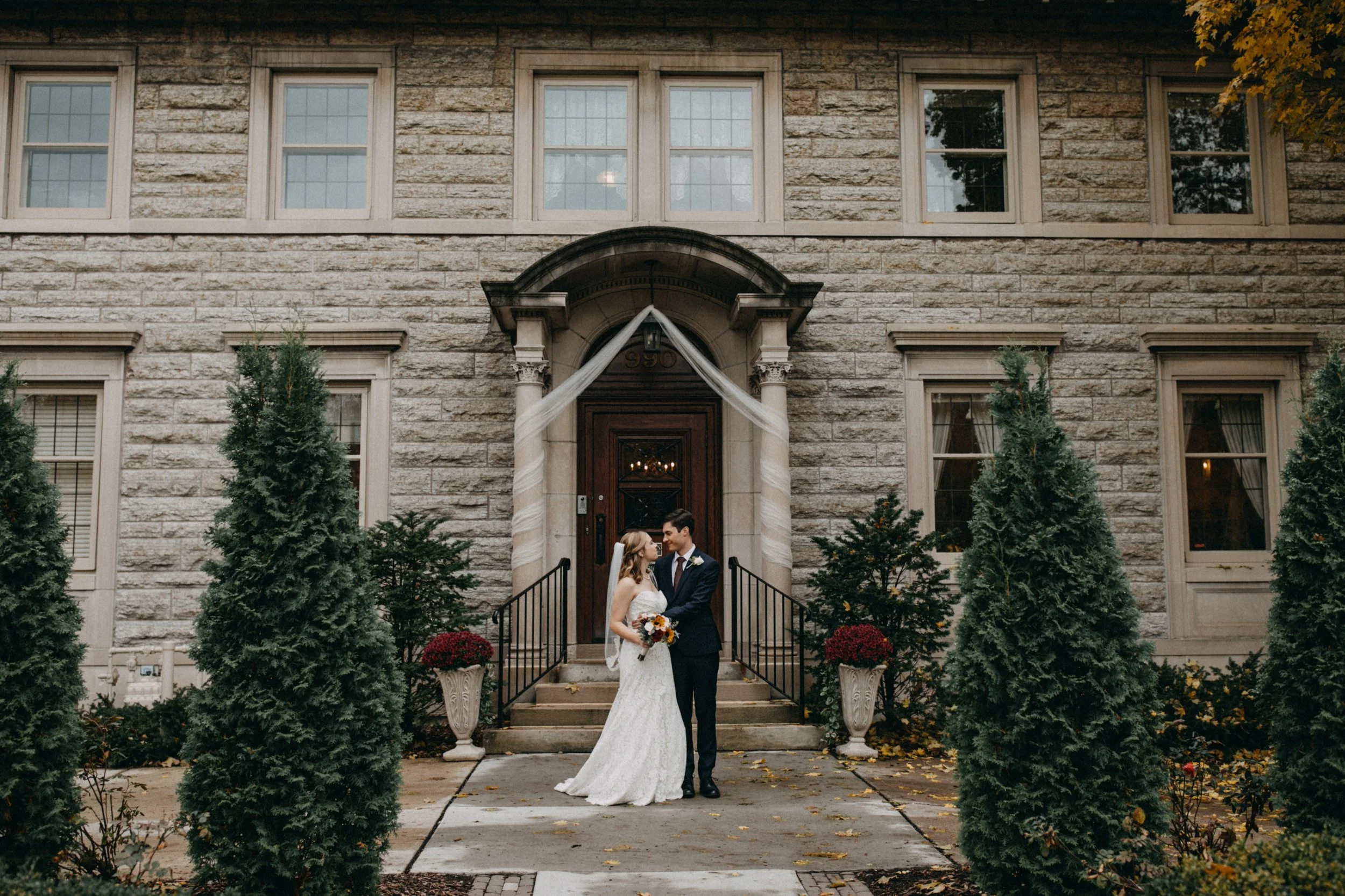 Bride and groom standing in front of their St Paul College Club on their wedding day