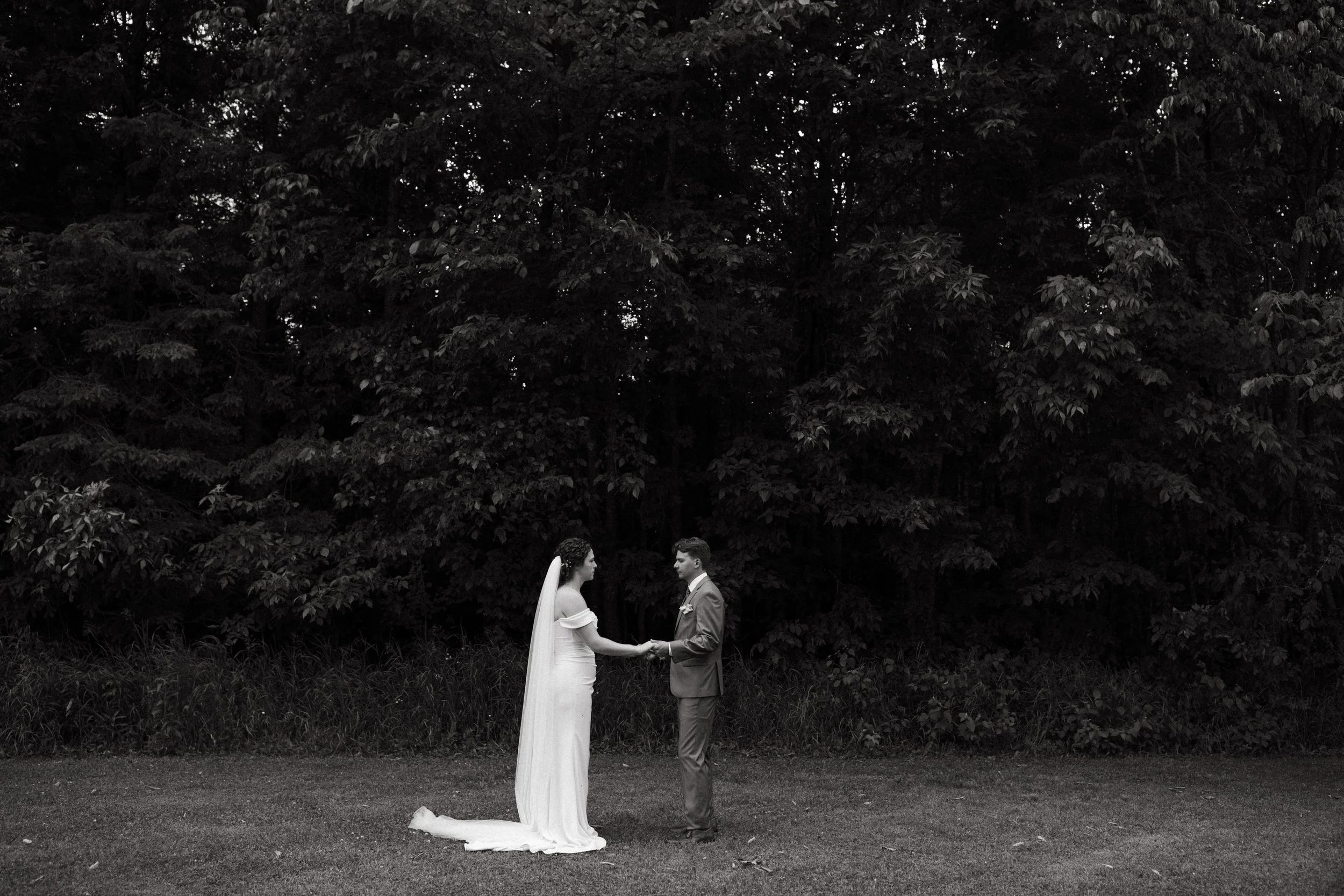 Bride and groom standing holding hands at their Minnesota barn wedding venue
