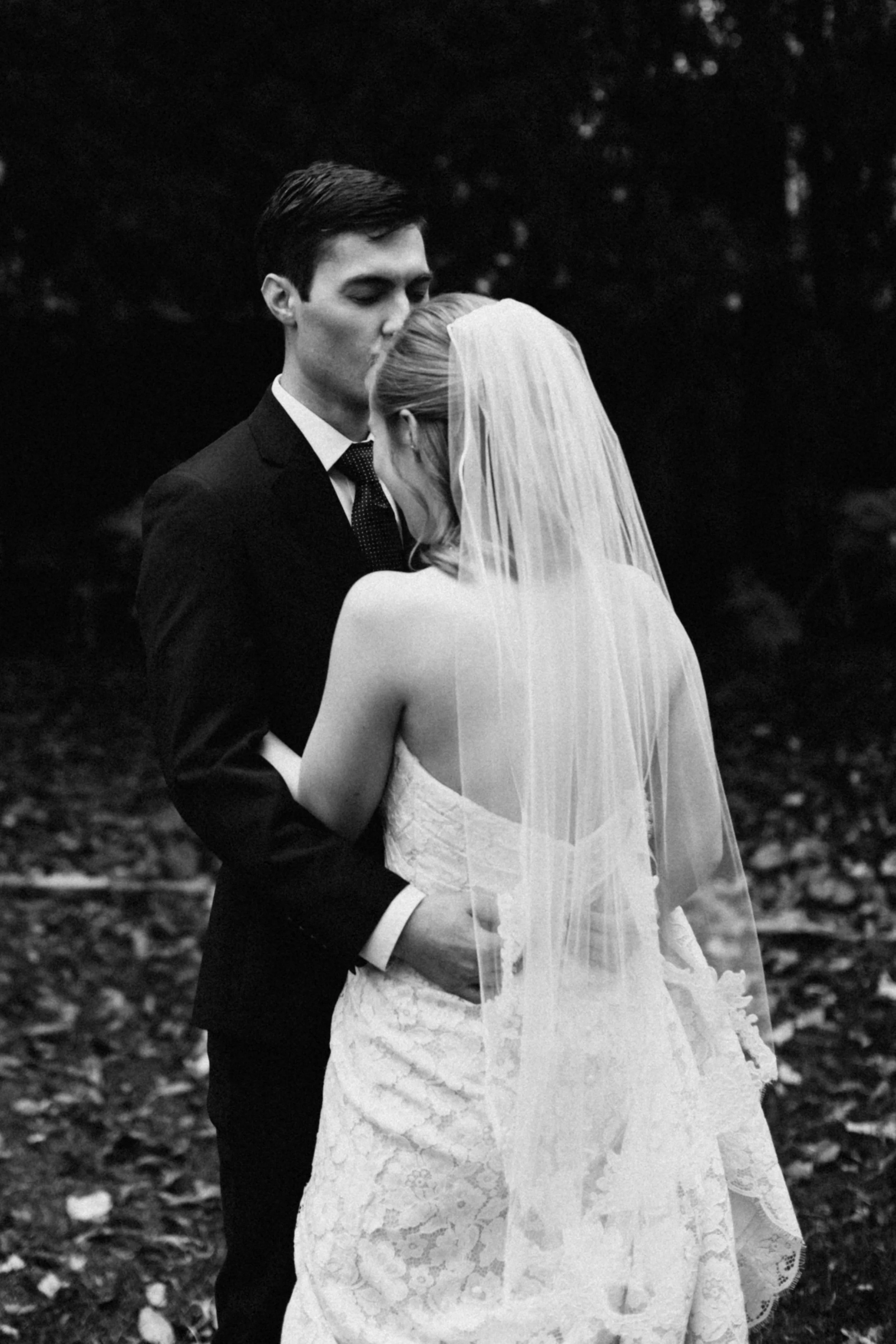 Groom kissing brides foreheard during their Minnesota fall wedding at the St Paul College Club