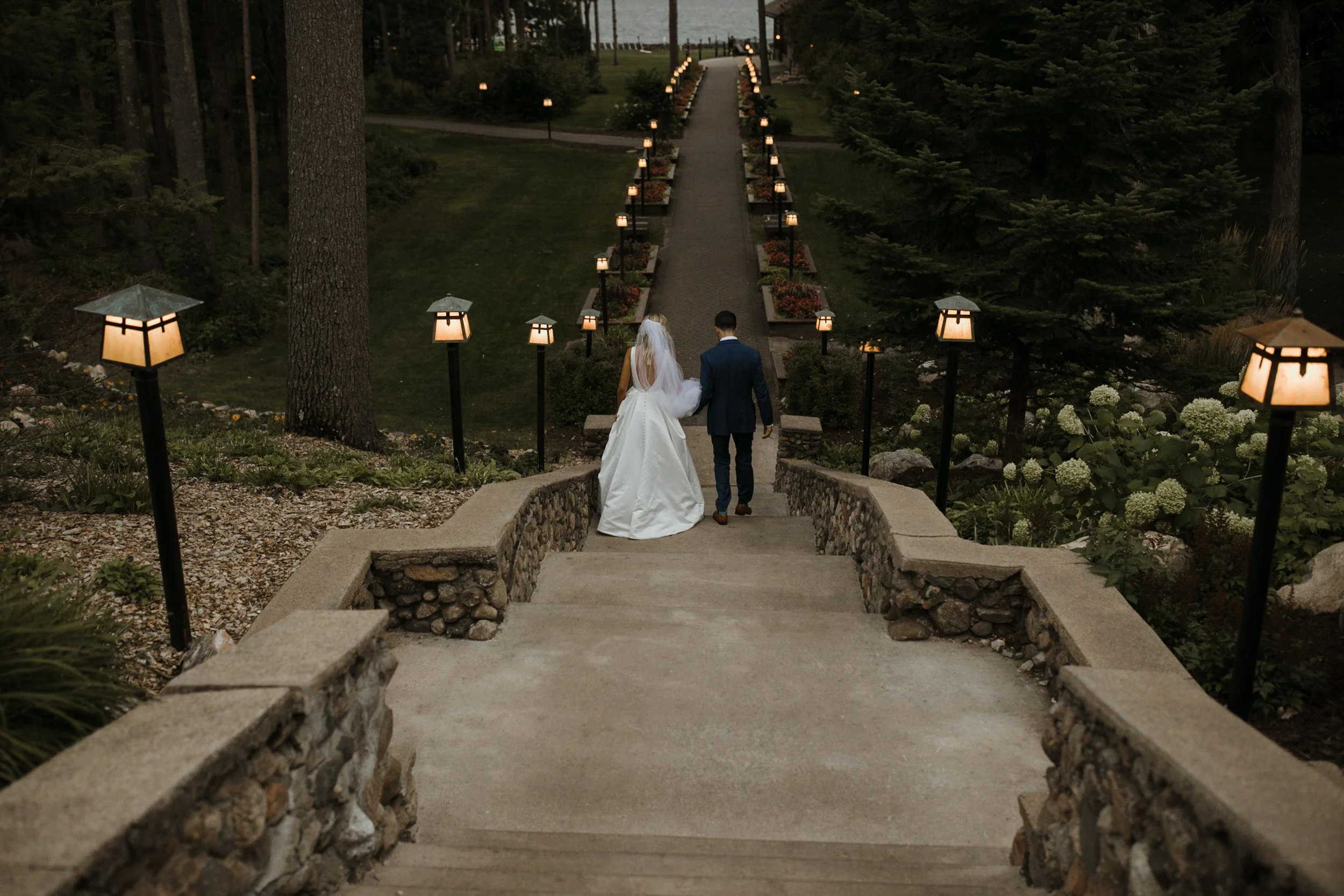 Bride and groom walking down stone staircase at Grand View Lodge in Nisswa, Minnesota