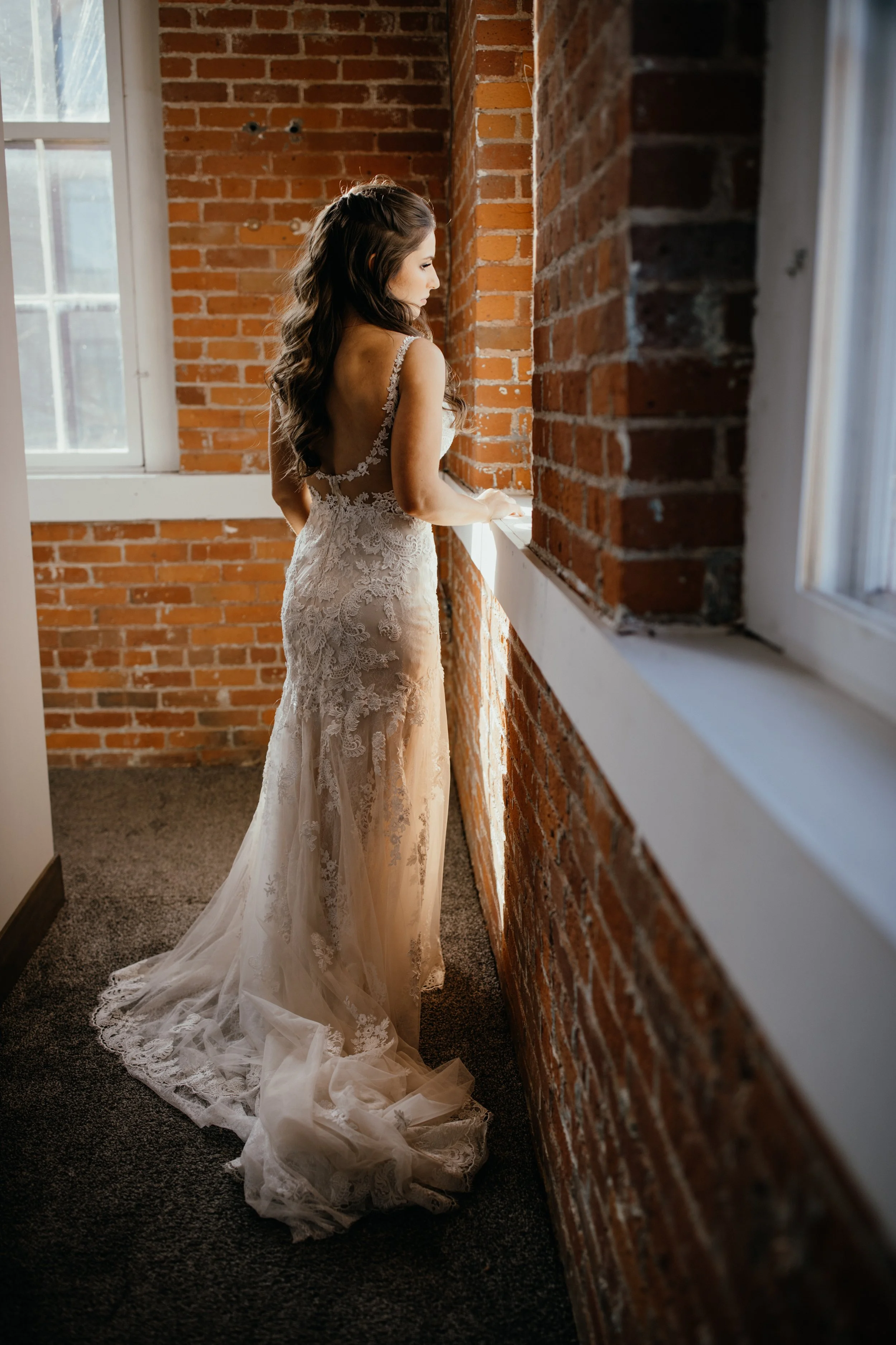 Bride wearing lace wedding dress inside bridal suite at JX venue in Stillwater, Minnesota
