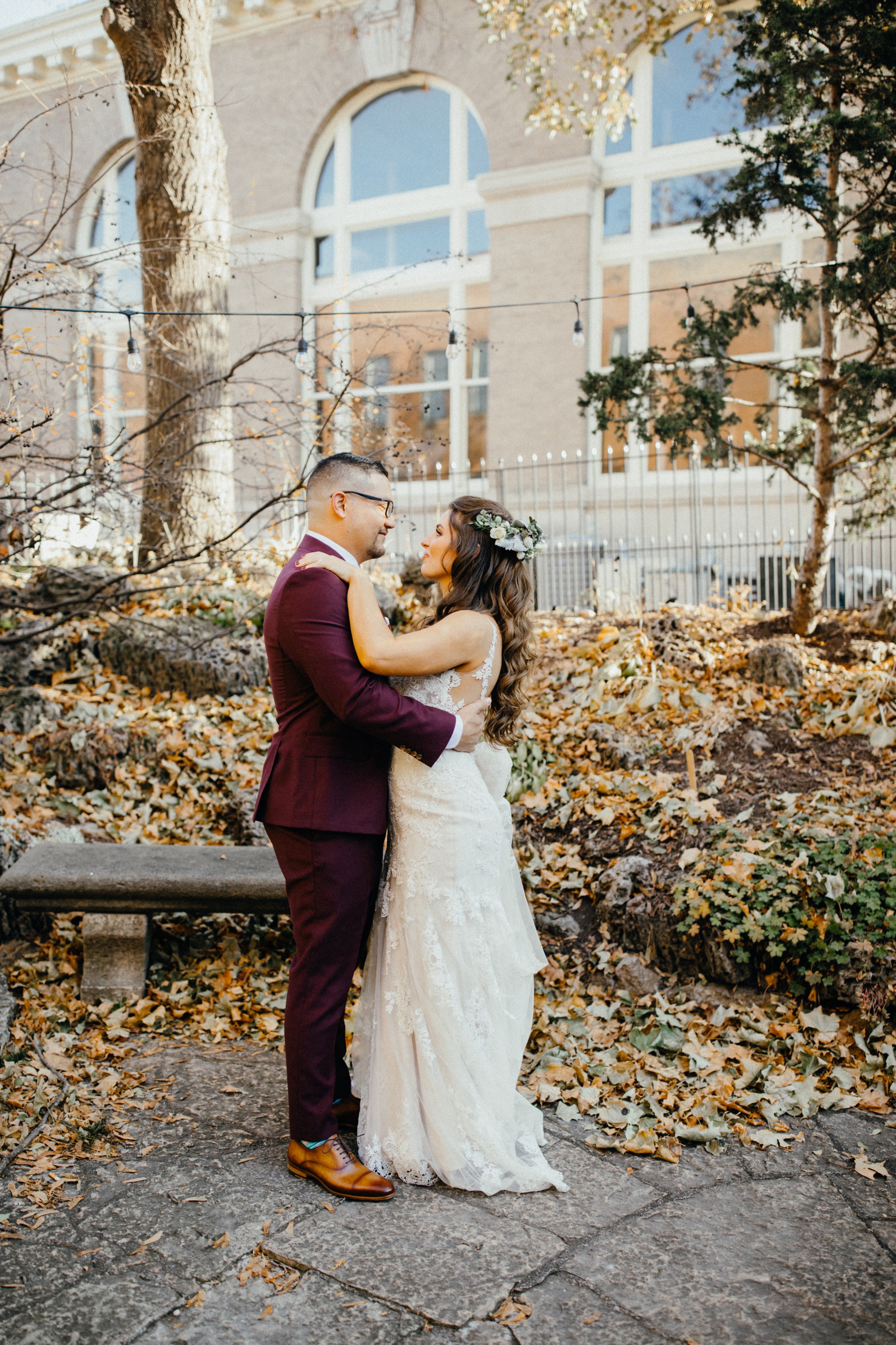 Bride and groom surrounded by leaves during fall wedding in Stillwater, Minnesota