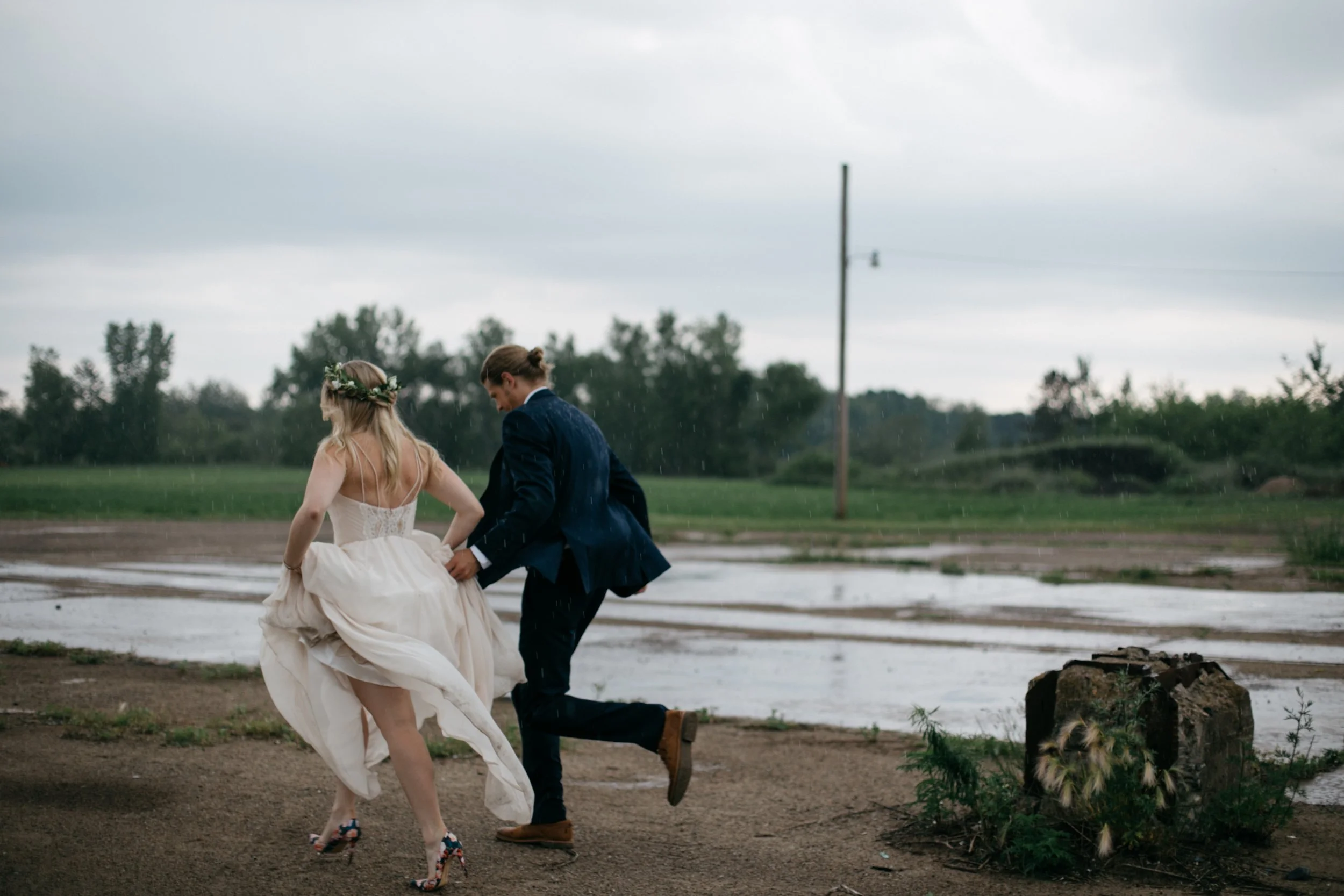 Bride and groom running in the rain at their Northern Pacific Center wedding in Brainerd, Minnesota