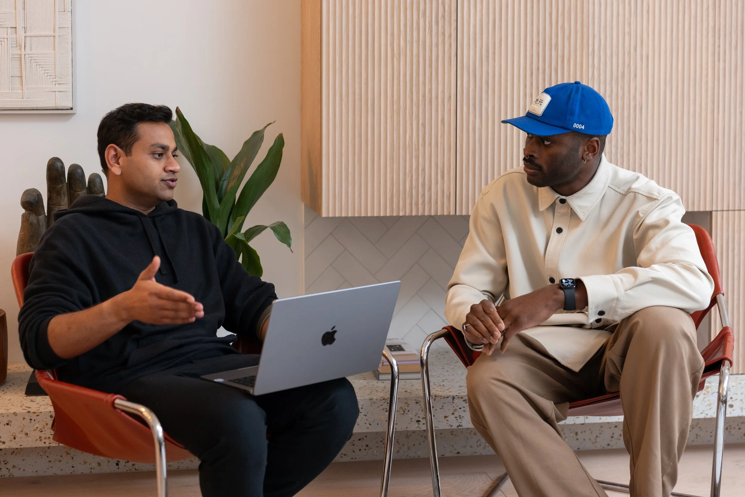 Two men are speaking with one gesturing to a laptop