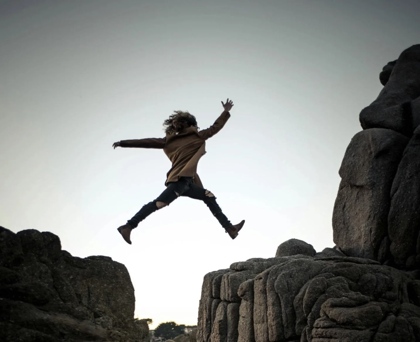 Woman jumping across crevice