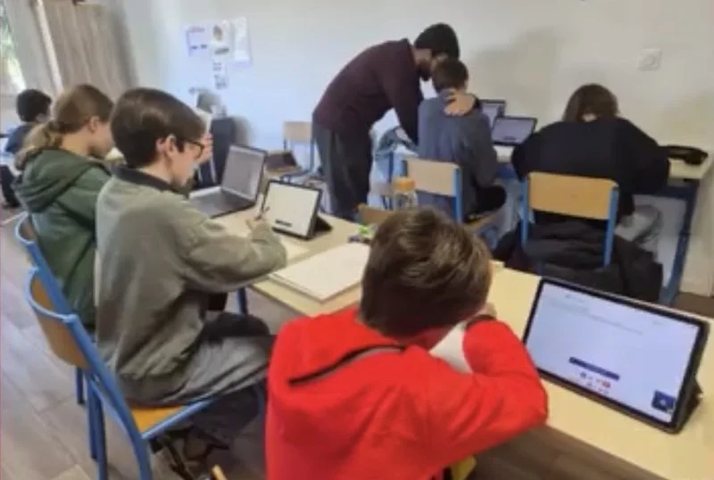 IA et enfants : classe de collégiens utilisant une plateforme pour l'aide aux devoirs dirigés. Cette plateforme utilise, en plus de l'humain,  un assistant IA pour accompagner l'élève dans ses apprentissages