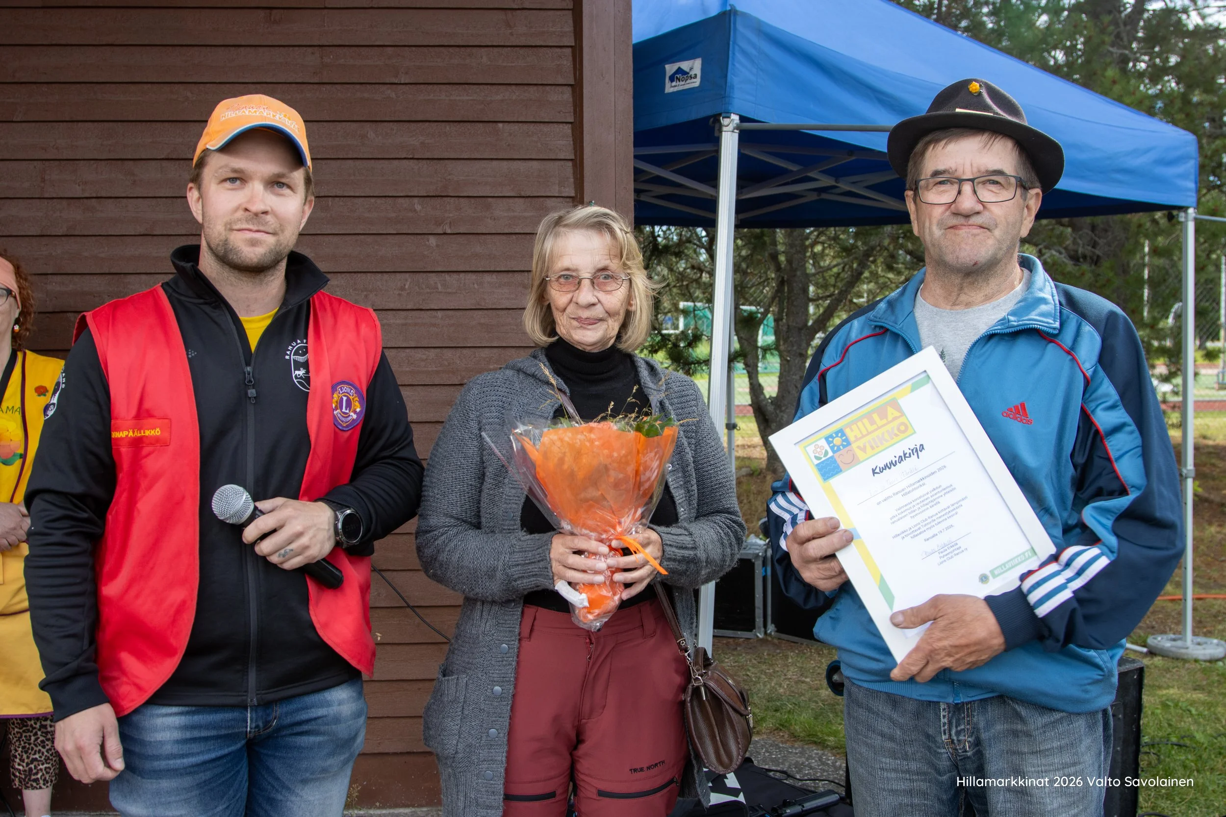 Hillamarkkinapäällikkö Jaakko Kouva (vas.) myönsi Hillatohtorin arvonimen ja asiaankuuluvan hatun Teuvo ja Eini Väärälälle.