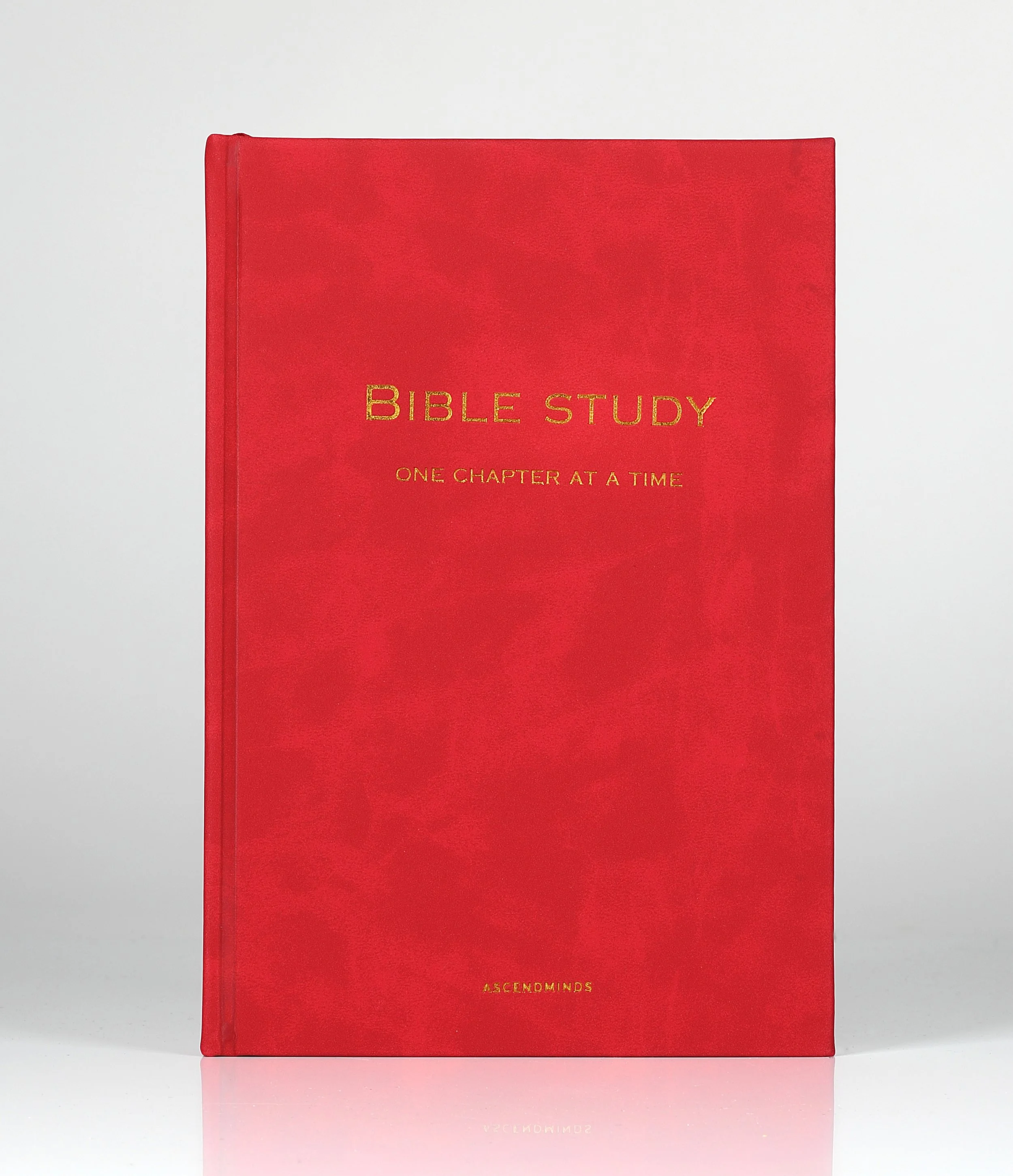 Red hardcover book titled 'BIBLE STUDY', with the subtitle 'ONE CHAPTER AT A TIME', and 'ASCENDMINDS' written at the bottom in gold letters, against a plain white background.