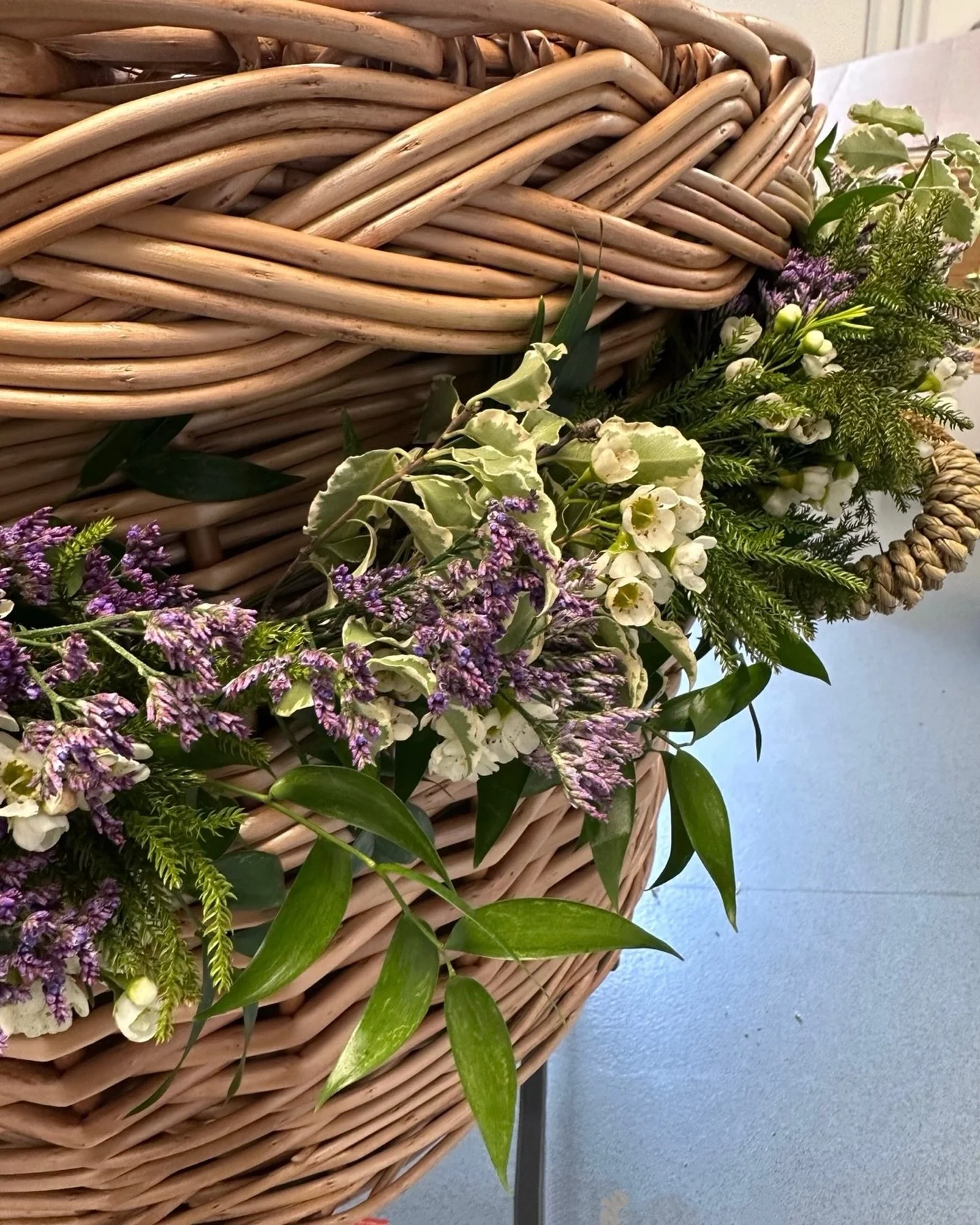 Garland on a wicker casket.

#funeralflowersbuckinghamshire 
#cheshamflorist