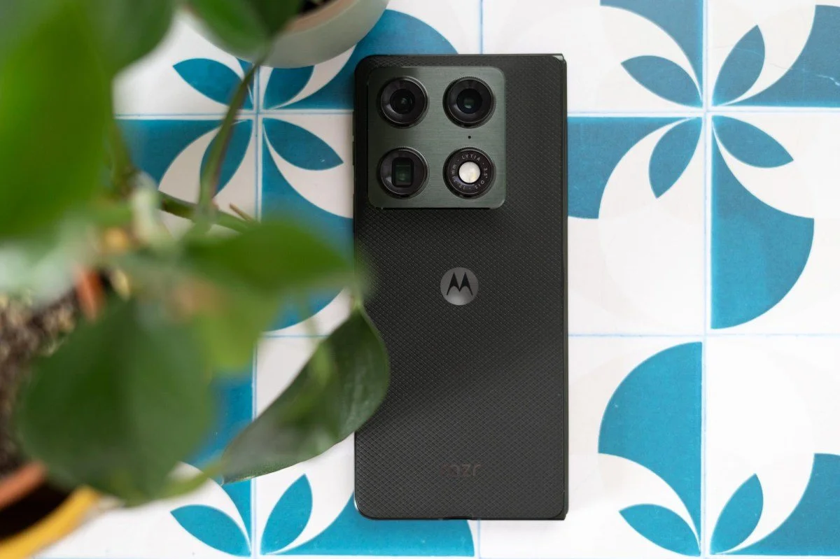 Motorola Razr Fold on blue-and-white patterned tiles with leaves at left, photographed by Allison Johnson / The Verge