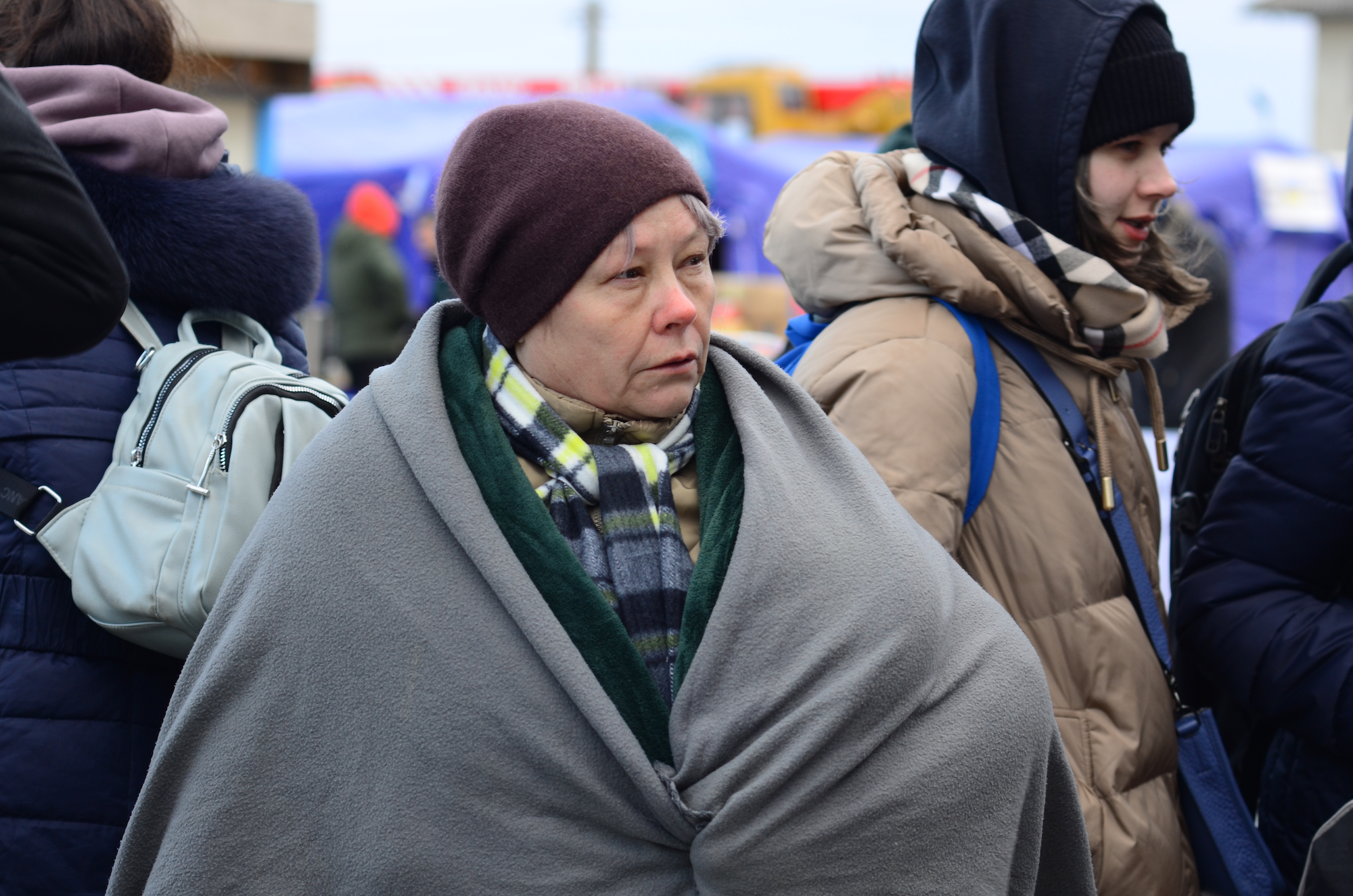 Refugees wrapped in blankets against the biting wind and freezing temperatures