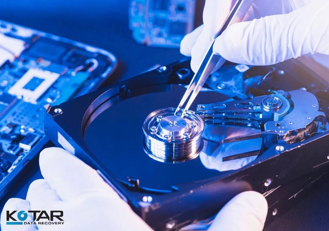 Hard drive being handled with precision tools during professional data recovery in a specialized lab environment.