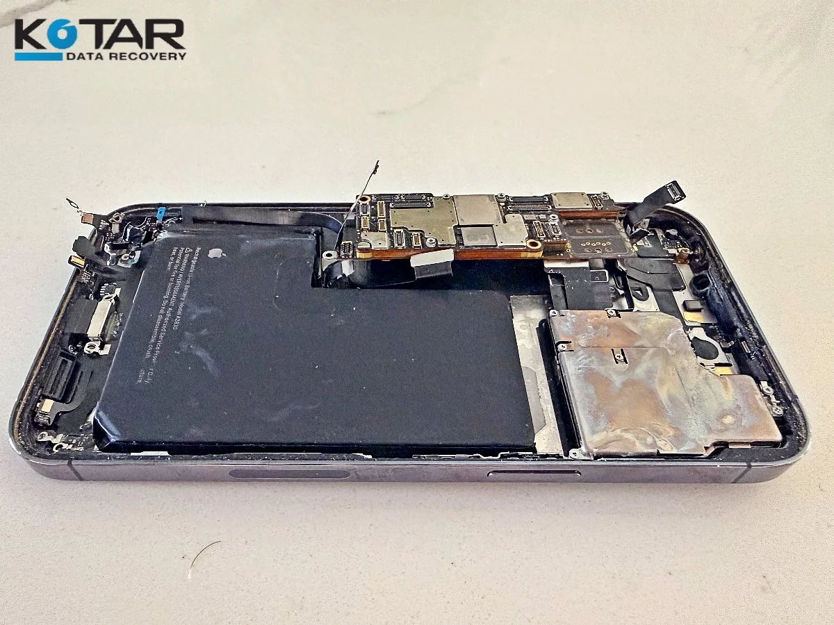 Disassembled smartphone showing its battery and logic board during a professional data recovery evaluation