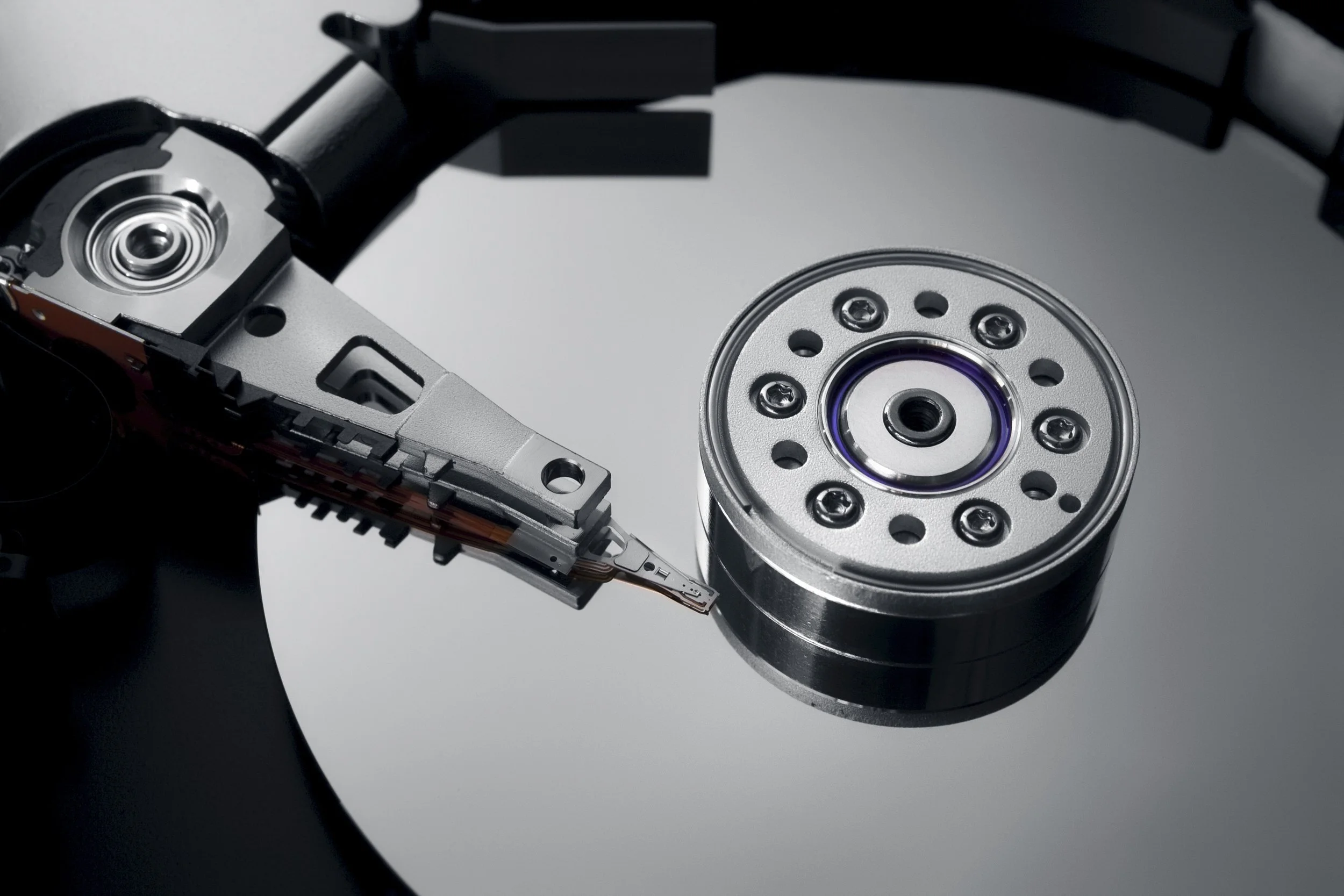 Open hard drive showing the platter and read/write head assembly representing professional data recovery services in San Jose.