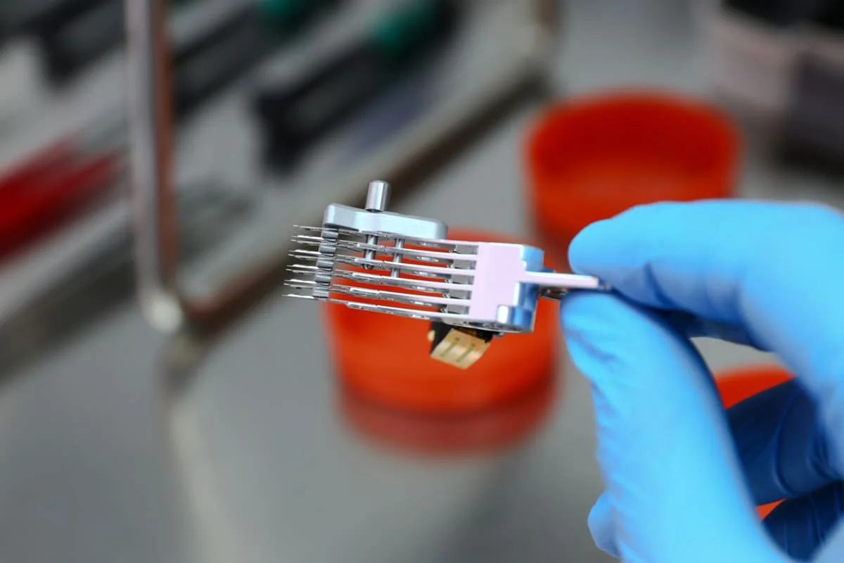 Data recovery engineer handling a hard drive component during professional recovery work in a specialized laboratory environment.