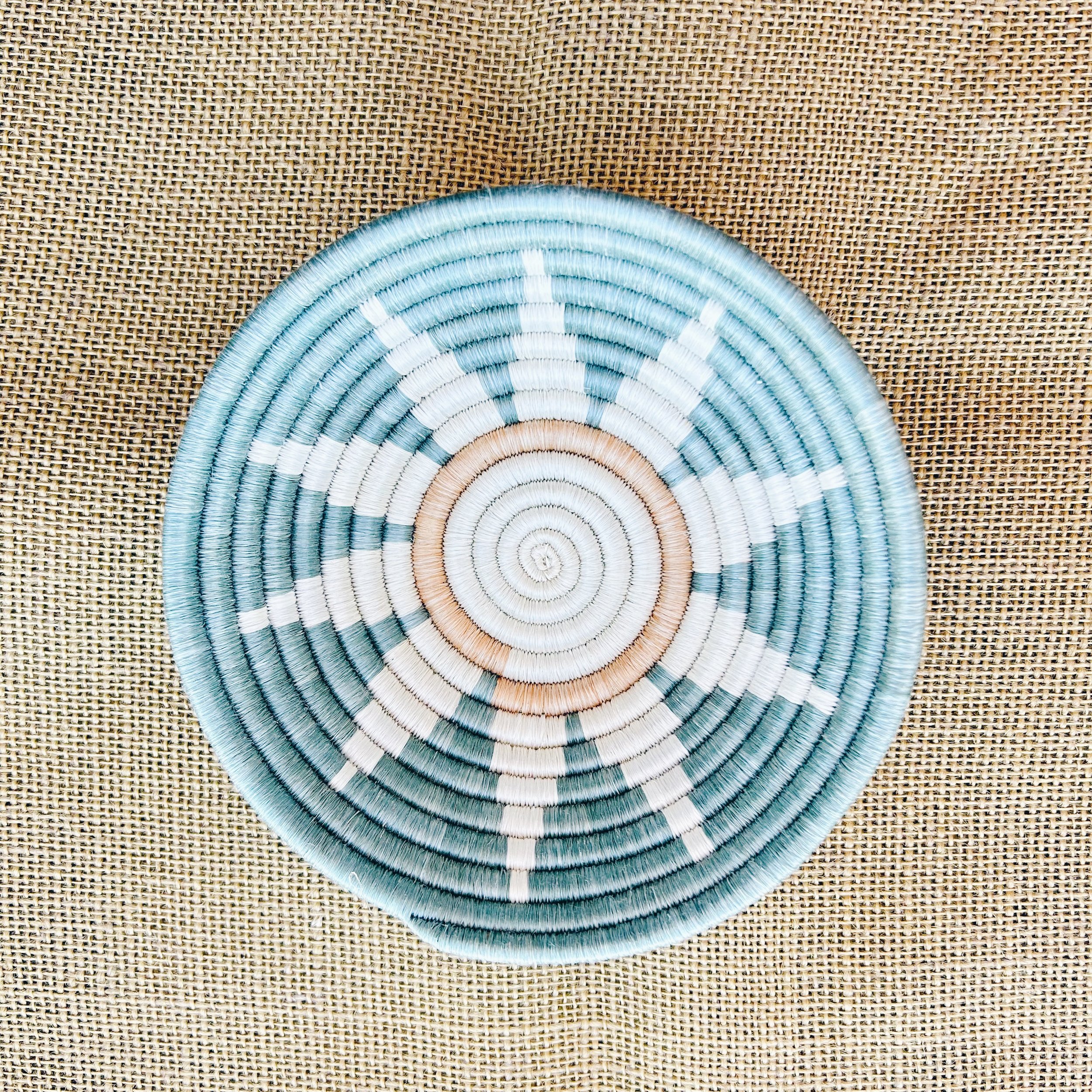 The Zuba Woven Bowl in Teal is shown from the top so the sunburst pattern is easily visible.