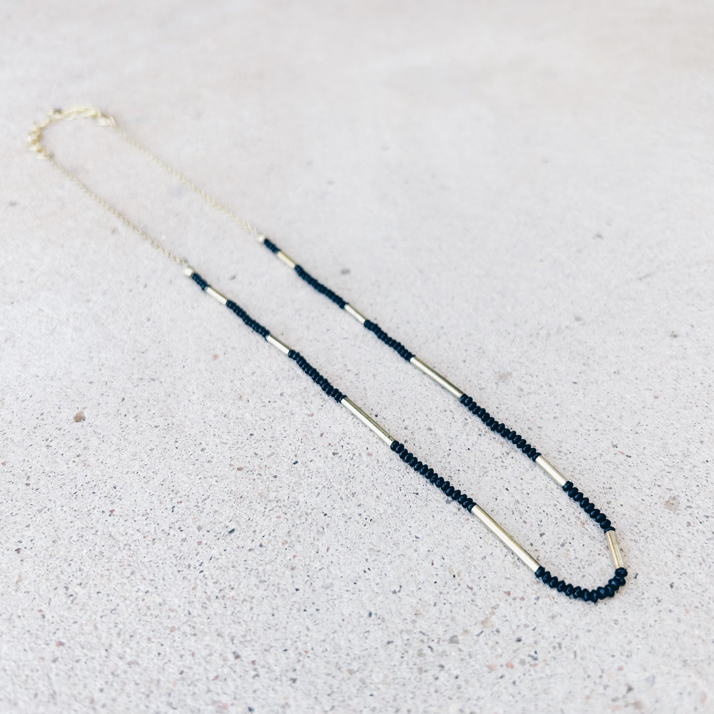 The Morse Code Necklace has great texture from black seed beads and shiny brass tube beads.