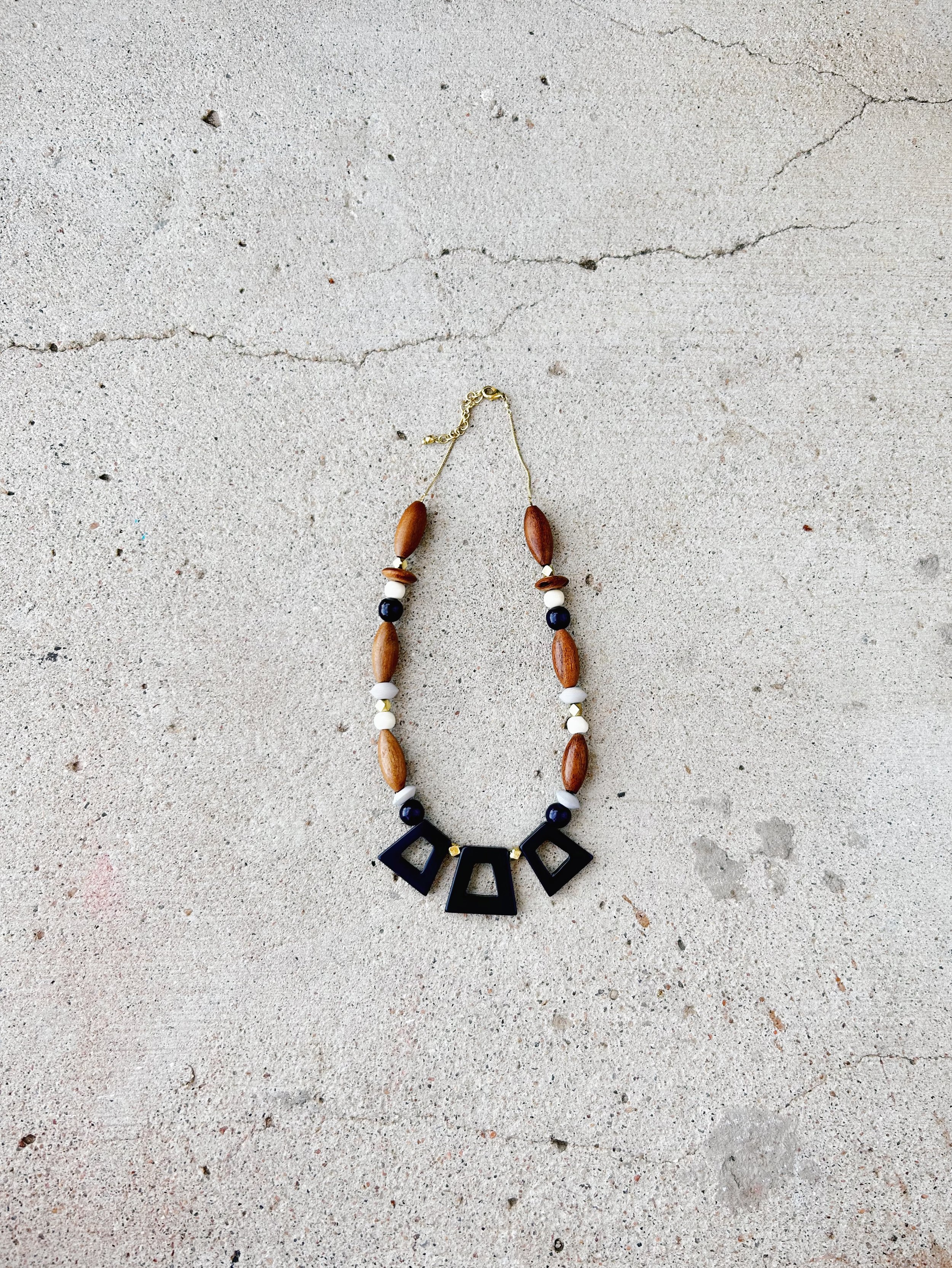 The Kolkata Necklace is shown against a light grey concrete background.