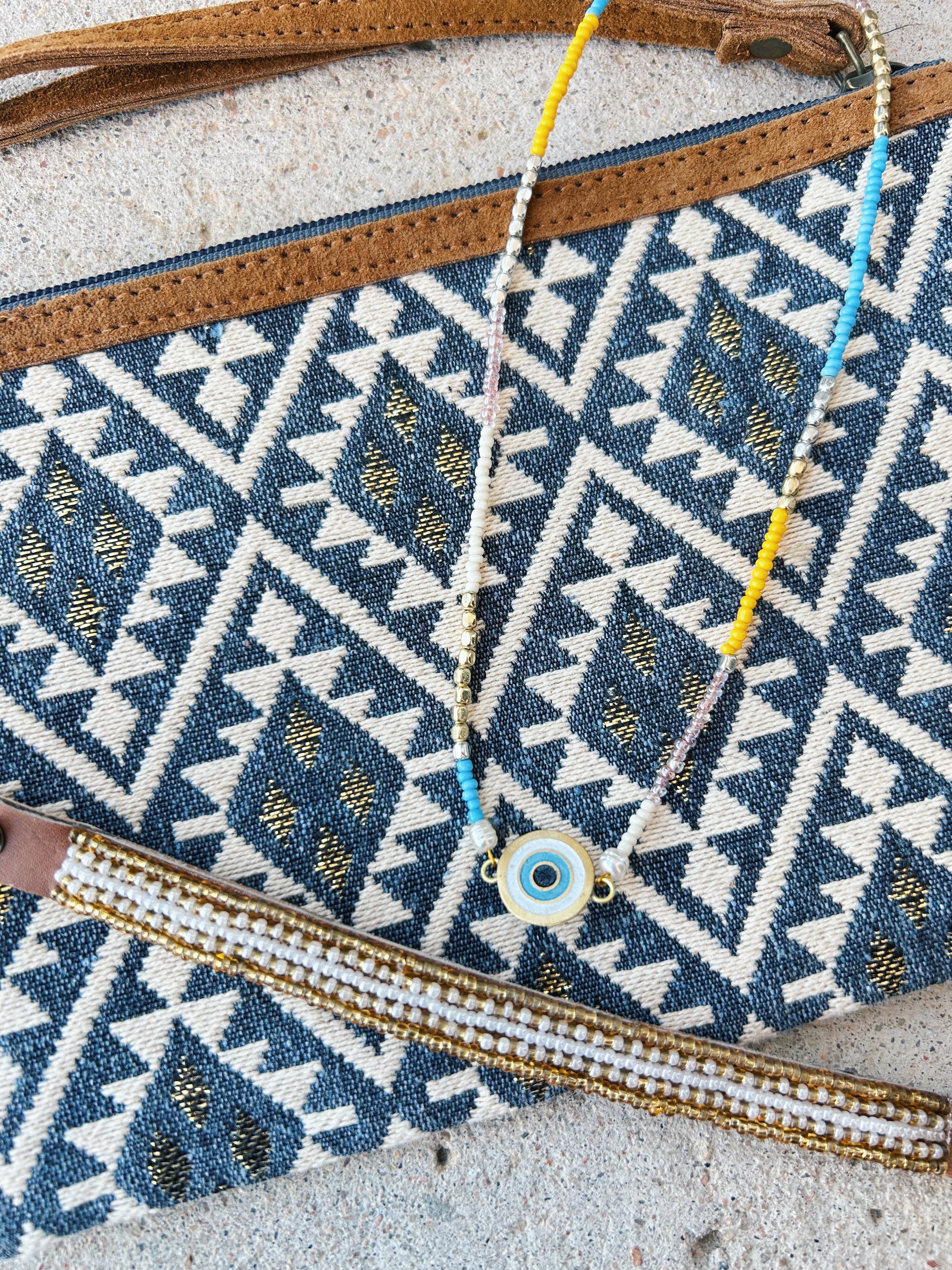 The Double Vision Necklace matches well with the Sonoma Clutch Purse and Standard Neutral Bracelet in Gold.